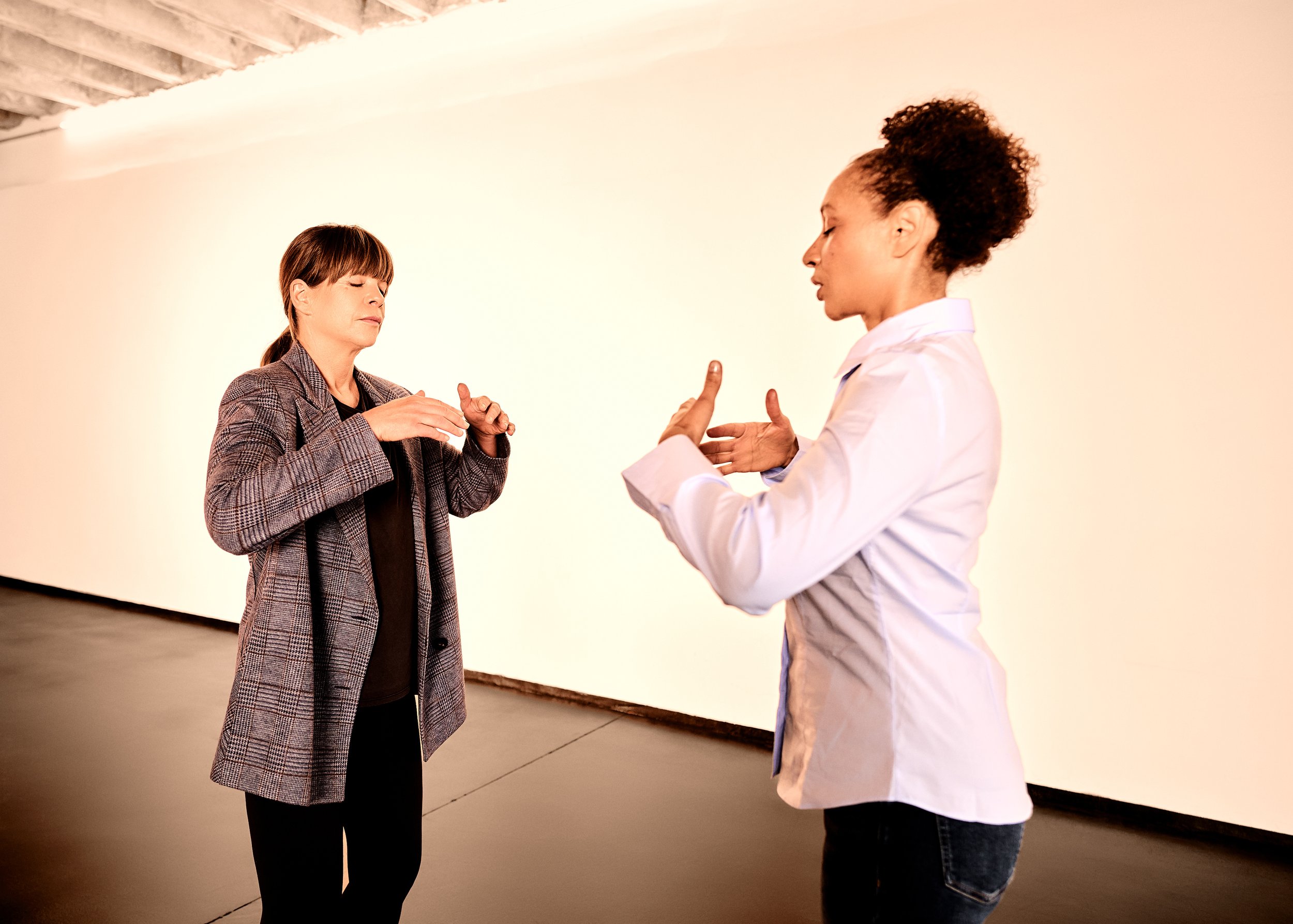 Gaëlle Georges und Teilnehmende beim Resilienz-Coaching. Eine trägt eine graue kariert Jacke, die andere eine weiße Bluse.