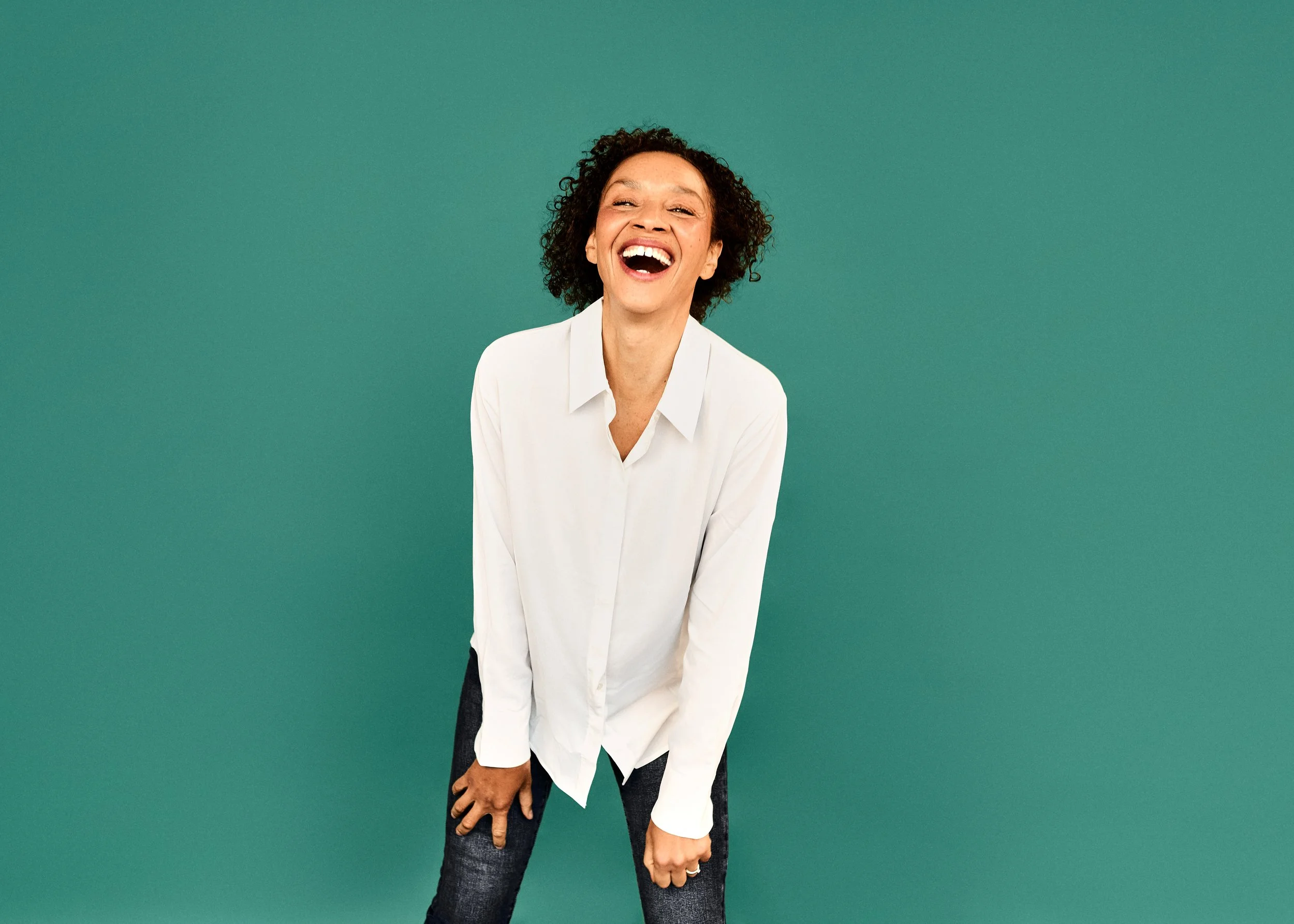 Gaëlle Georges lächelt in weißem Hemd, vor einem grünen Hintergrund