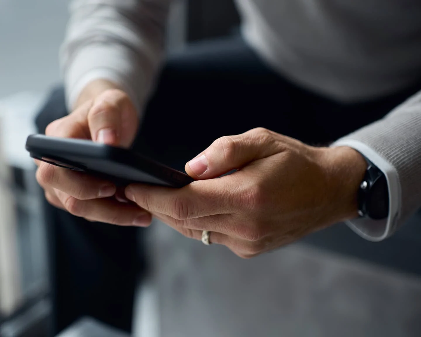 Nahaufnahme von einer Person, die ein Smartphone hält und es benutzt.