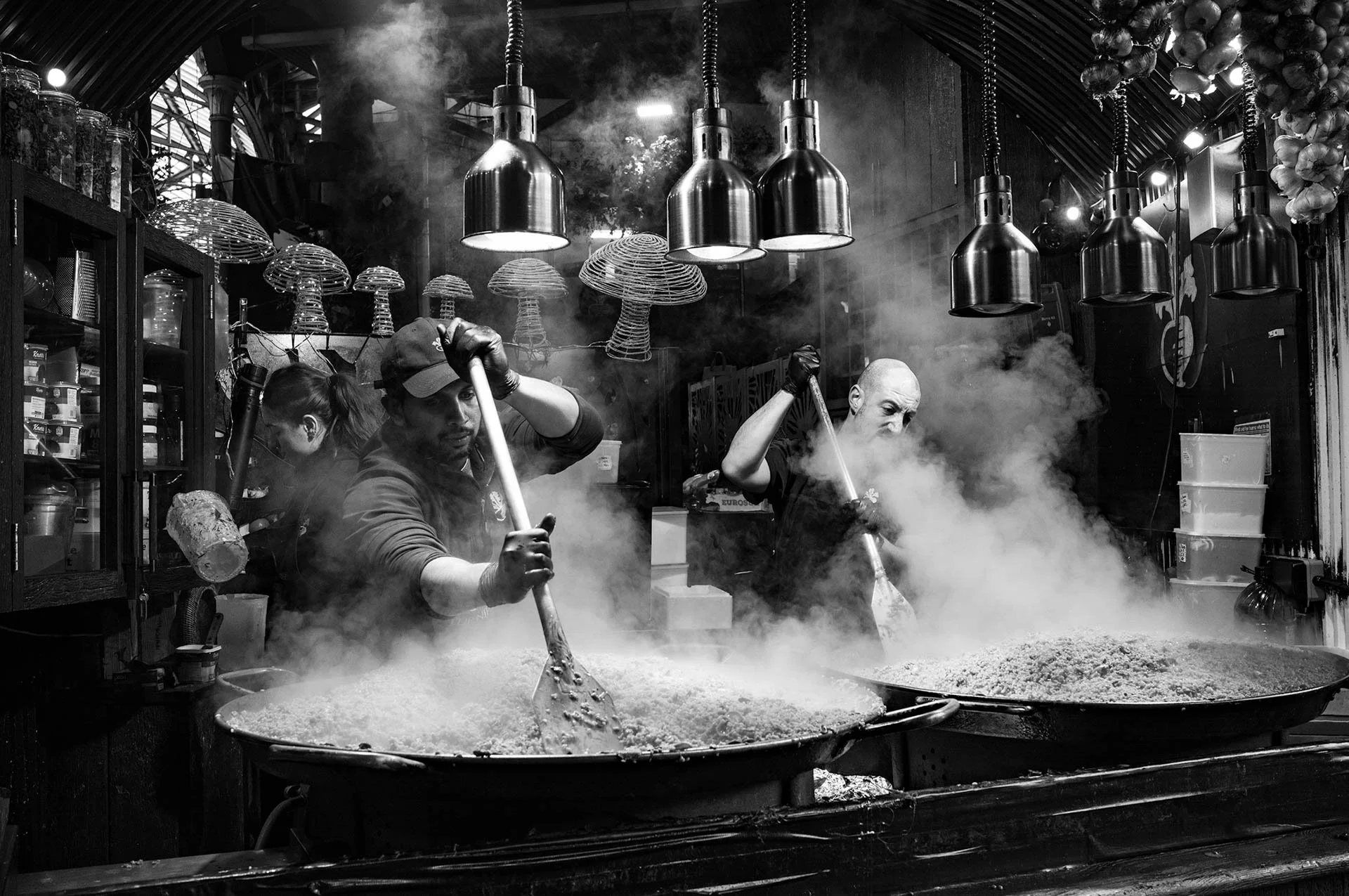 "Workers In Borough Market" I took this early one morning of workers preparing the mushroom risotto for sale in Borough Market. Taken with my Leica M11 Monochrome and APO 35mm Summicron lens.