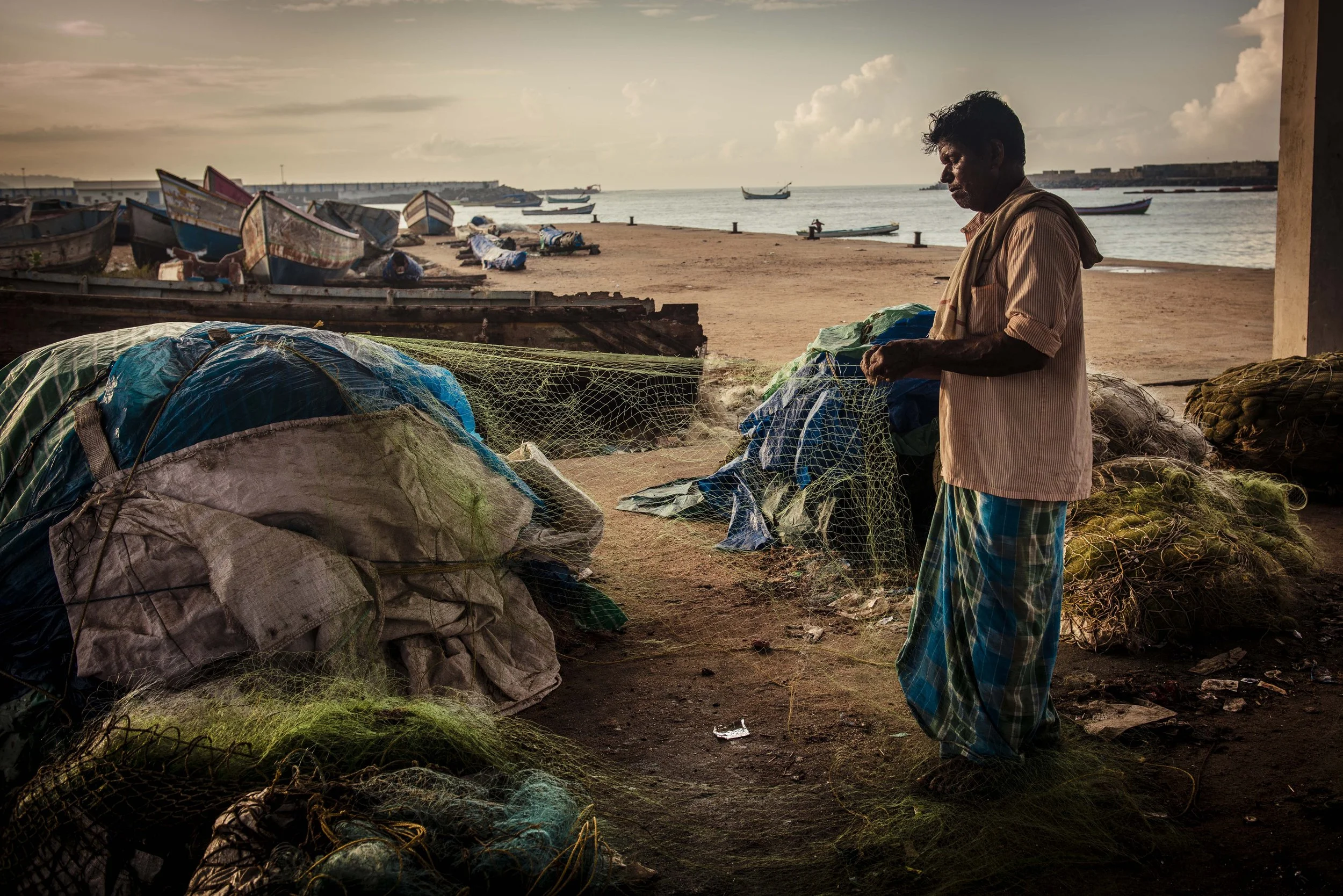 Fisherman repairing nets at Vizhinjam International Seaport Thiruvananthapuram