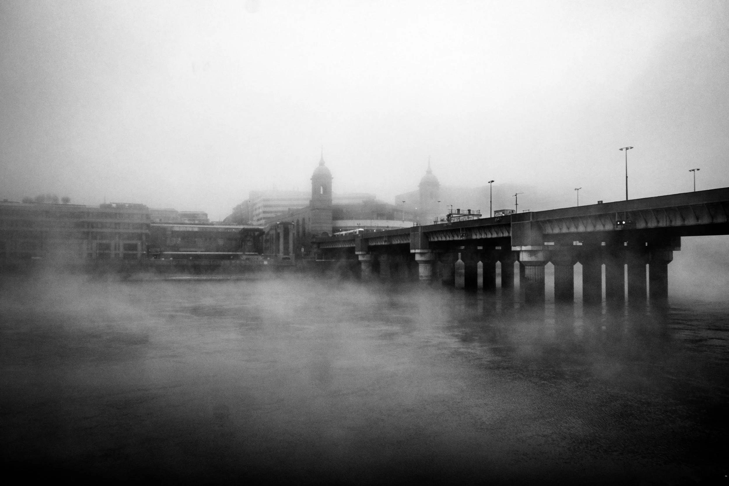 Black and white foggy morning over  Cannon Street Railway Bridge, London