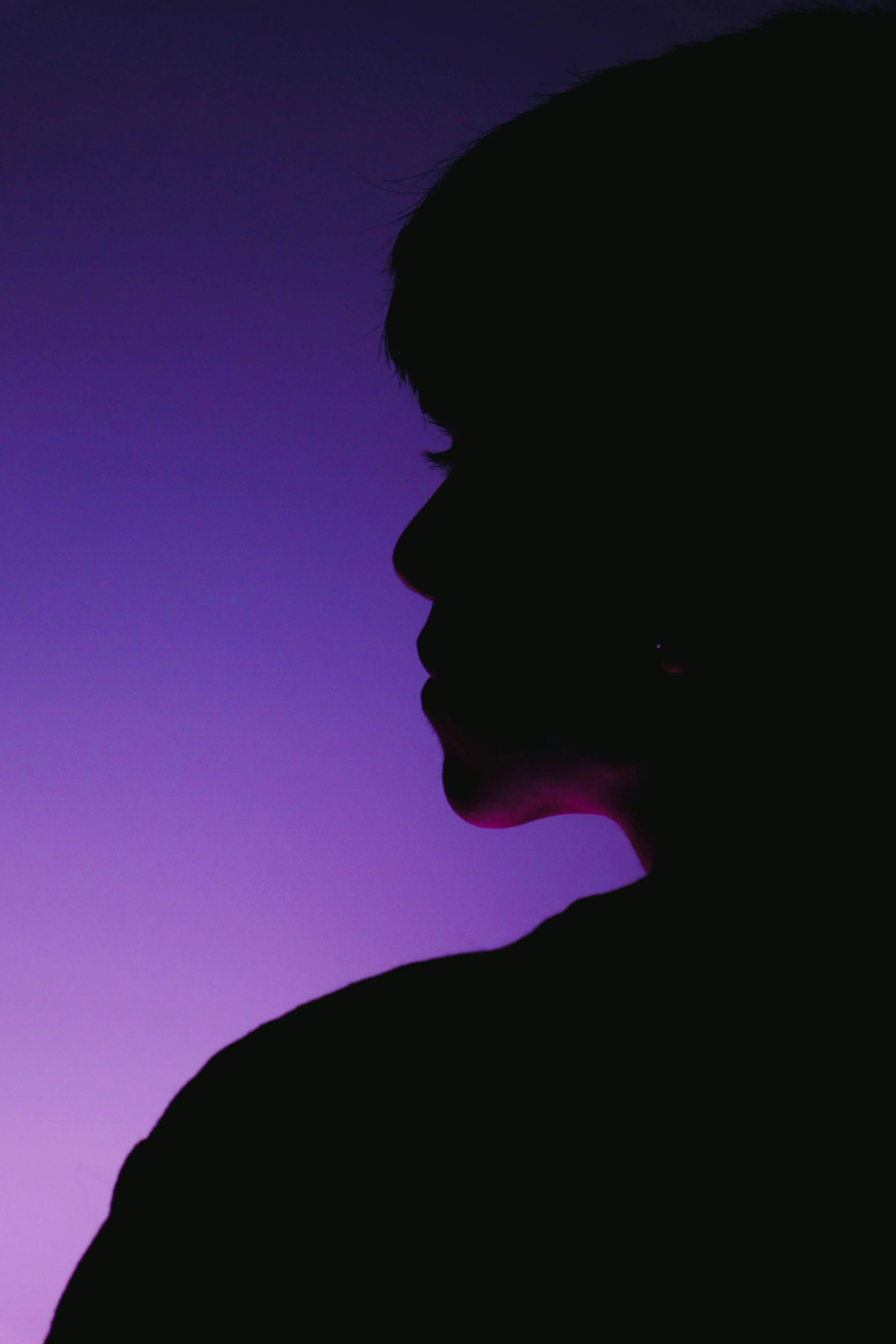 Silhouette of a person's profile against a purple and blue gradient background