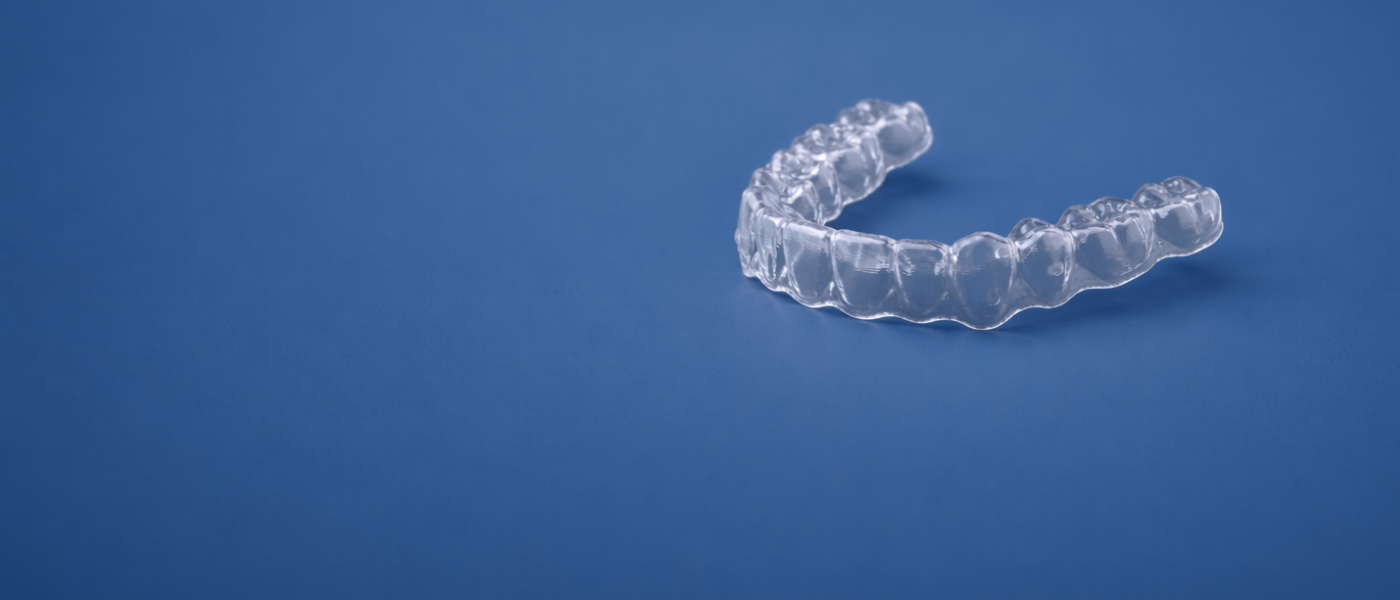 Clear aligners on a plain blue background