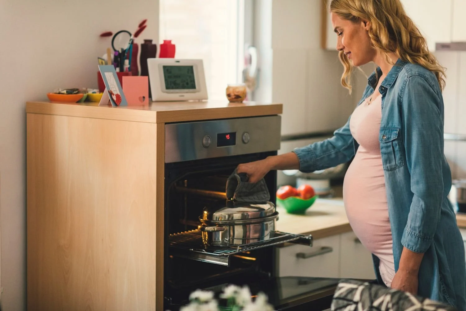 Pregnant woman planning postpartum nutrition and meal preparation during third trimester