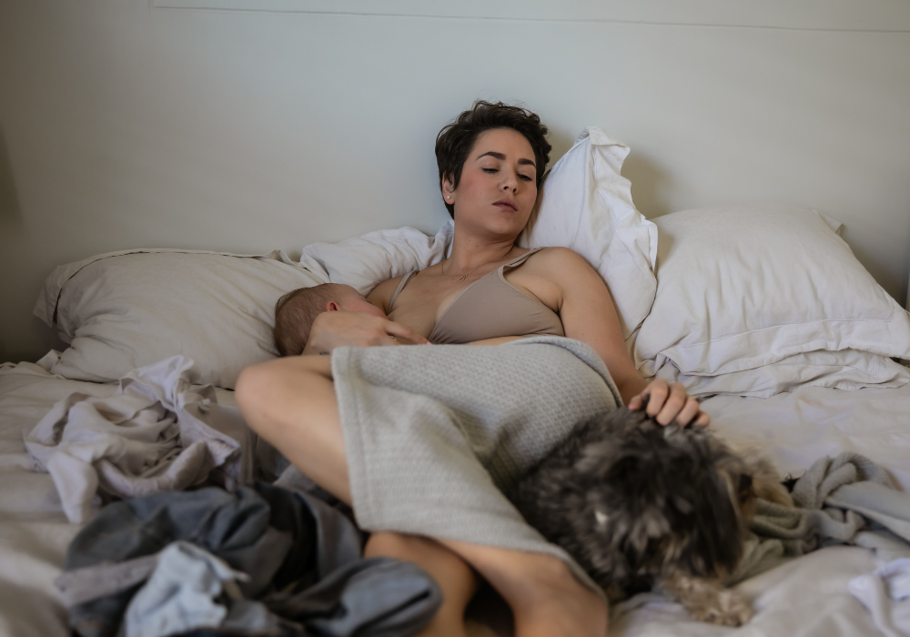 New mother resting with newborn baby during the fourth trimester postpartum recovery period