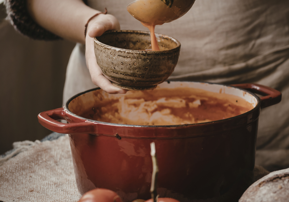 This image shows a woman ladling stew into a bowl. Stew is a perfect postpartum food.