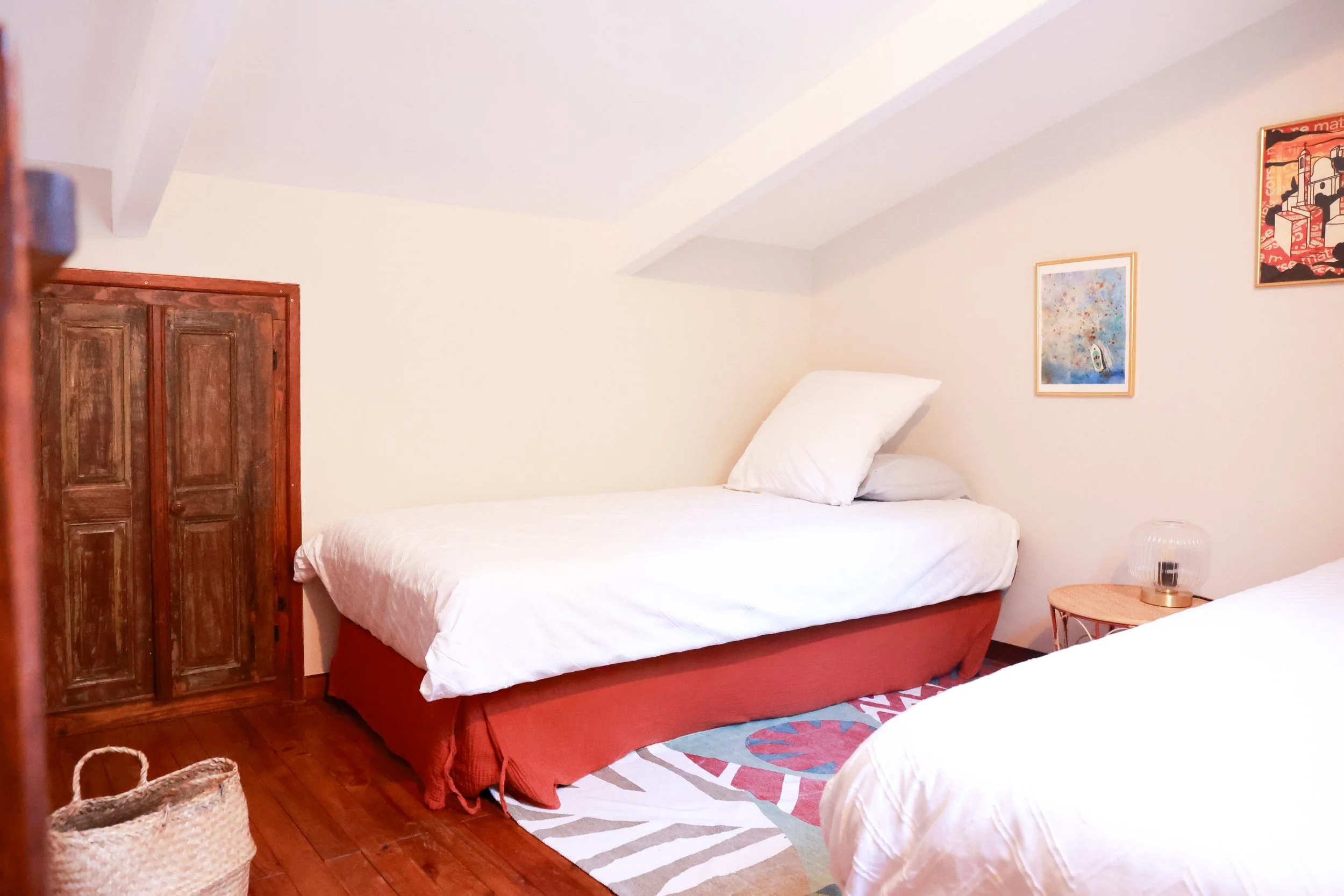 Mezzanine ouverte avec deux lits simples en 90, espace nuit cosy sous pente, idéale pour enfants ou amis dans la maison Casa L’Ombria.