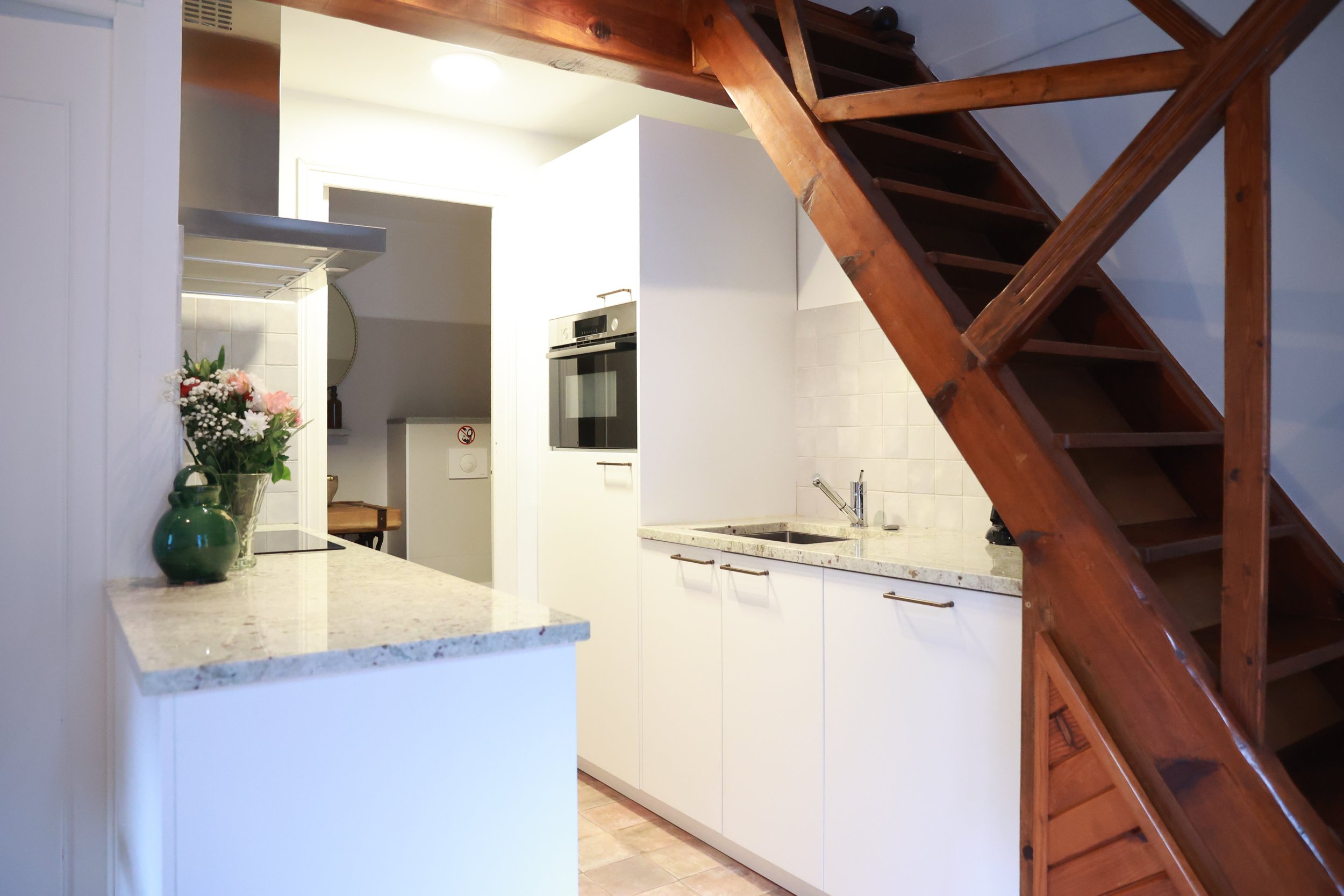 Cuisine équipée avec escalier menant à la mezzanine, Casa l’Ombria à Nonza, Cap Corse