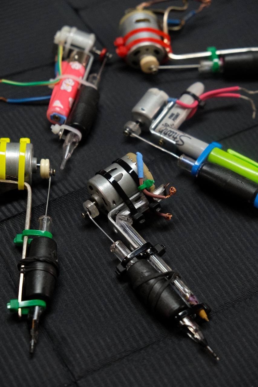 Various disassembled electrical components and tools laid out on a black surface, including motors, wires, and screwdrivers.