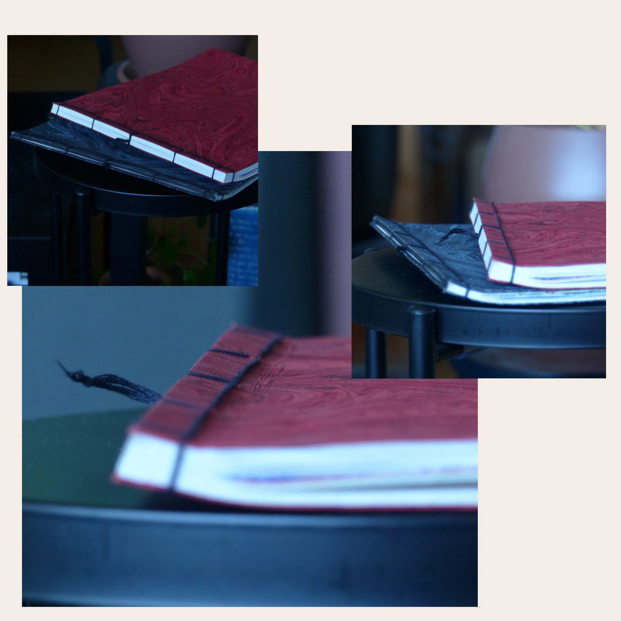Deux livres empilés, l'un rouge à motifs marbrés et l'autre noir à motifs marbrés, posés sur une surface noire.
