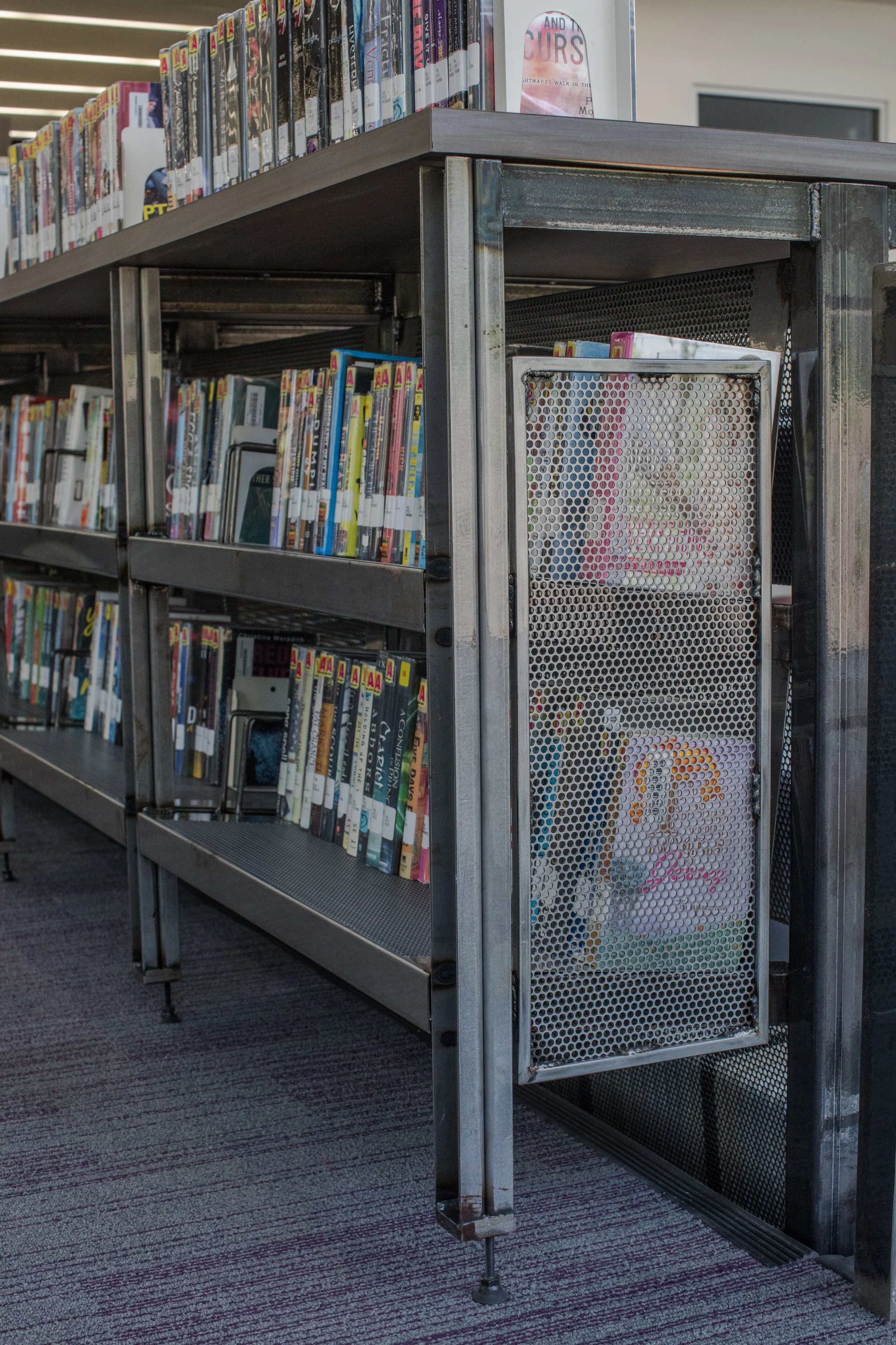 Library shelves filled with DVDs and VHS tapes in a public library.