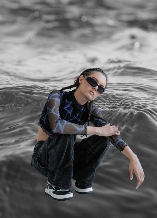 Design model wearing sunglasses with water in the background