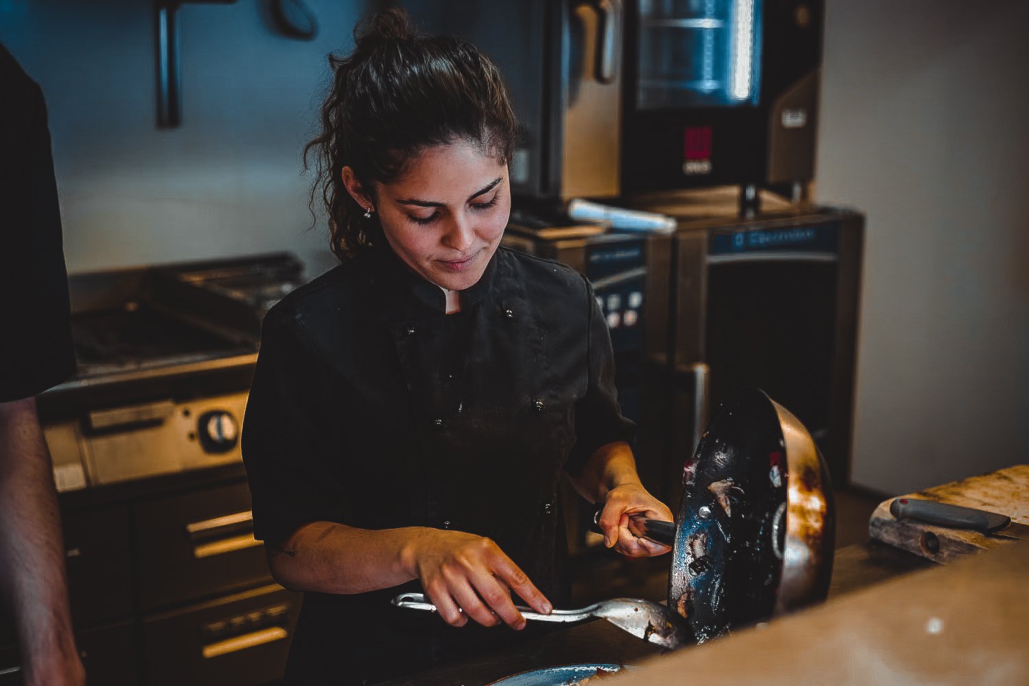 Bilde av en dame som lager mat på Sand Bar og Restaurant på Vesterøy