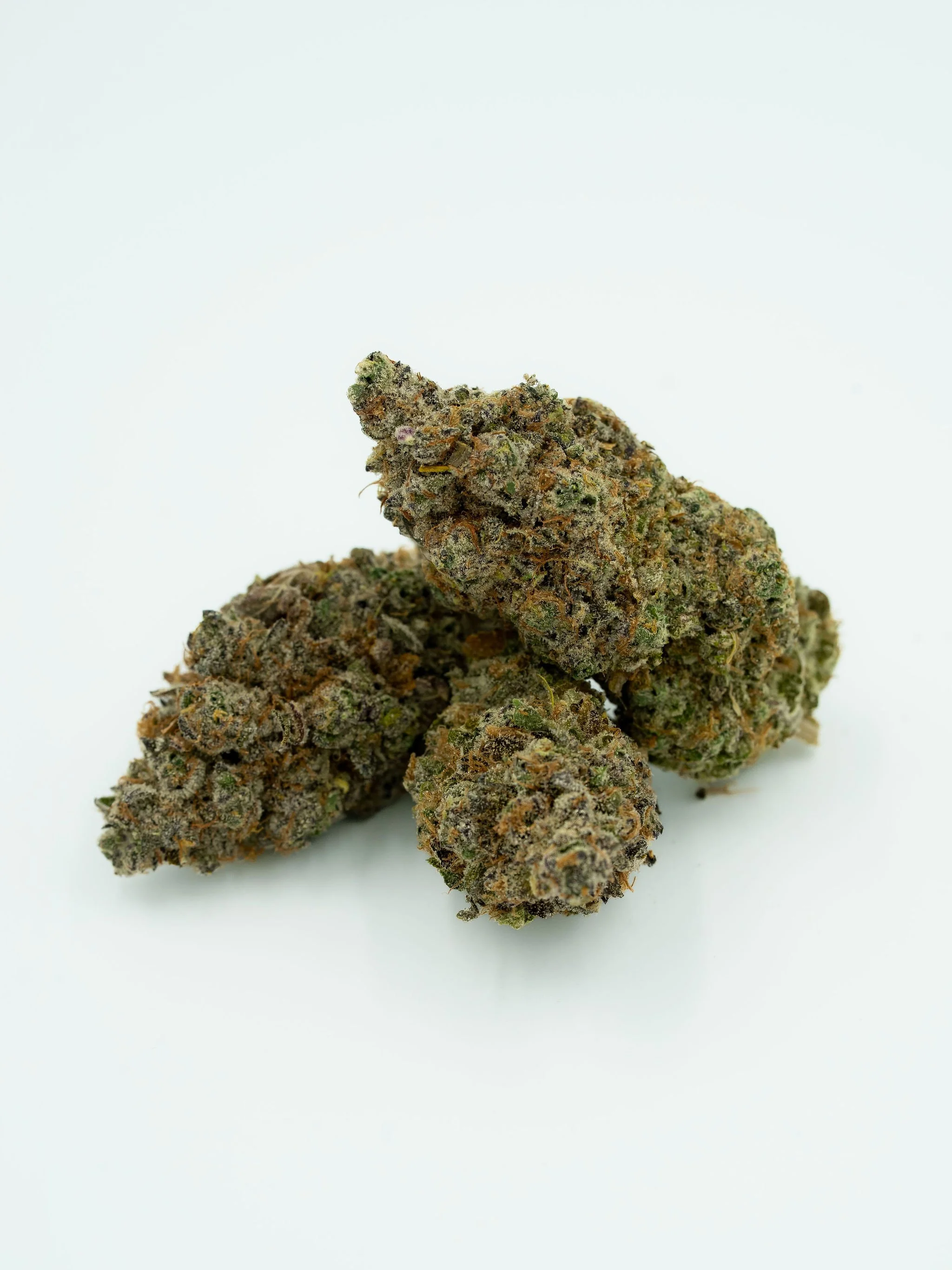 Three cannabis buds on a plain white background.