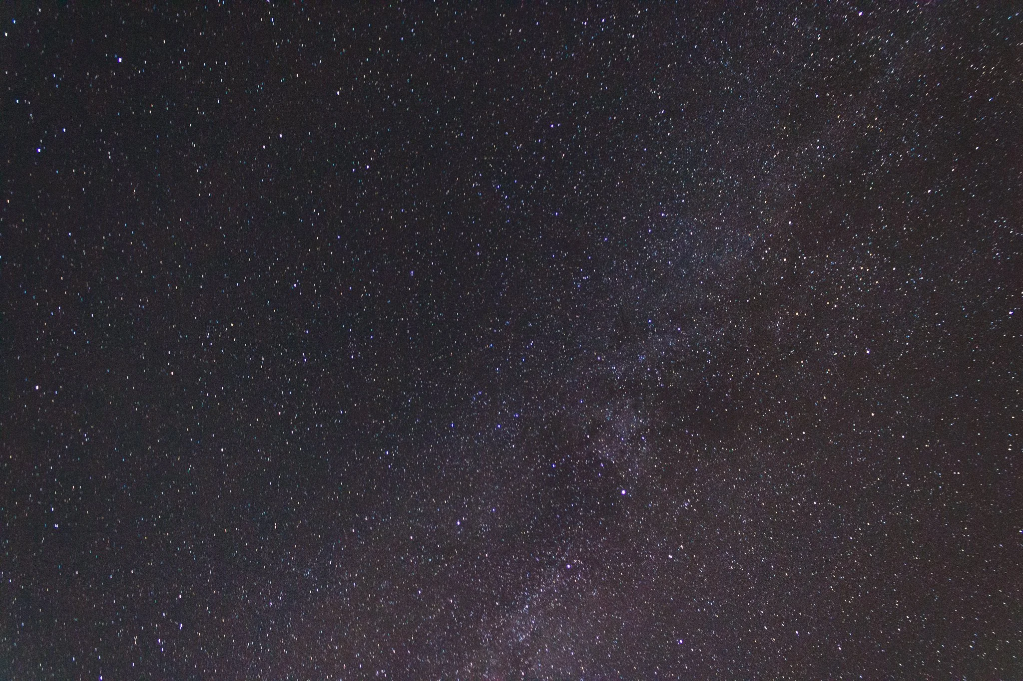 Starry night sky with numerous stars and some glimpses of the Milky Way galaxy.