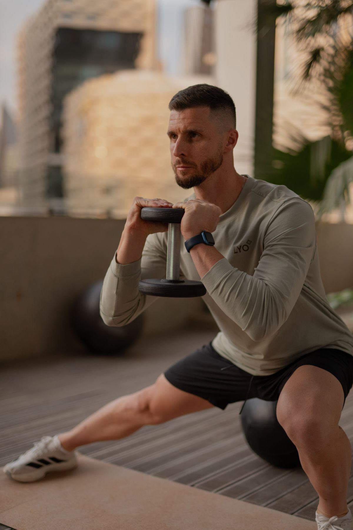 A man doing a side squat with a dumbell.