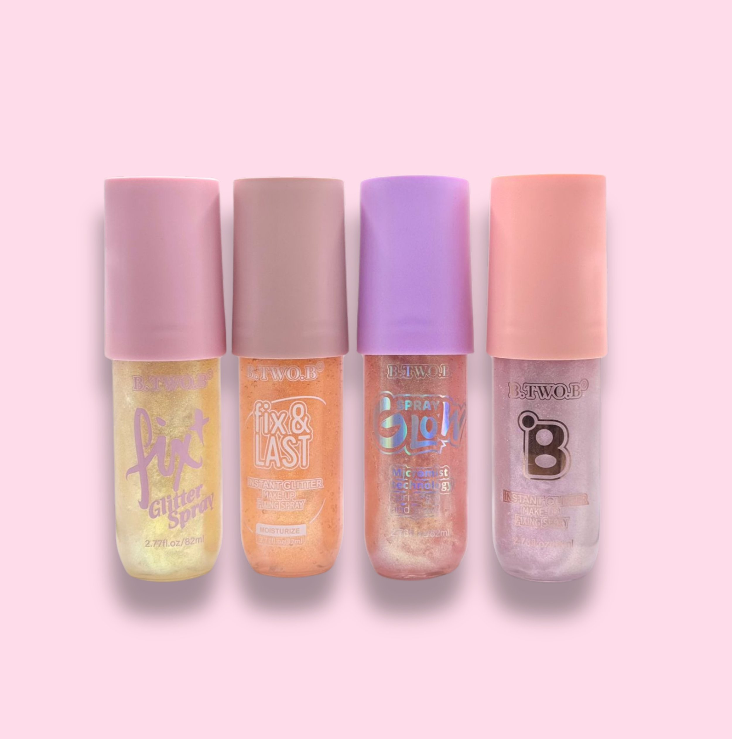 Quatro frascos de spray de glitter com tampas rosadas, cada um com cores e textos diferentes, alinhados sobre fundo rosa claro.