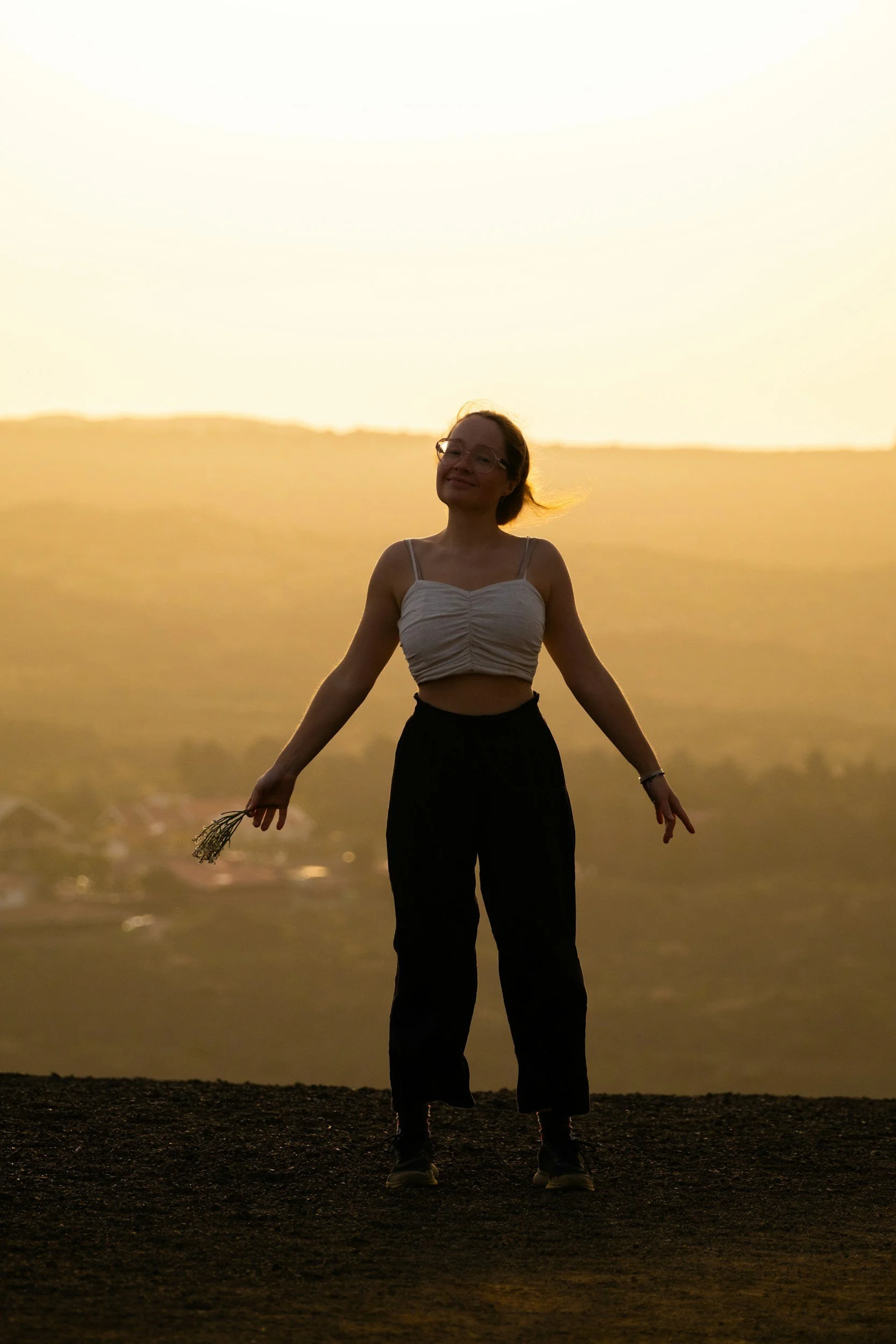 A woman grounds as she stands in nature