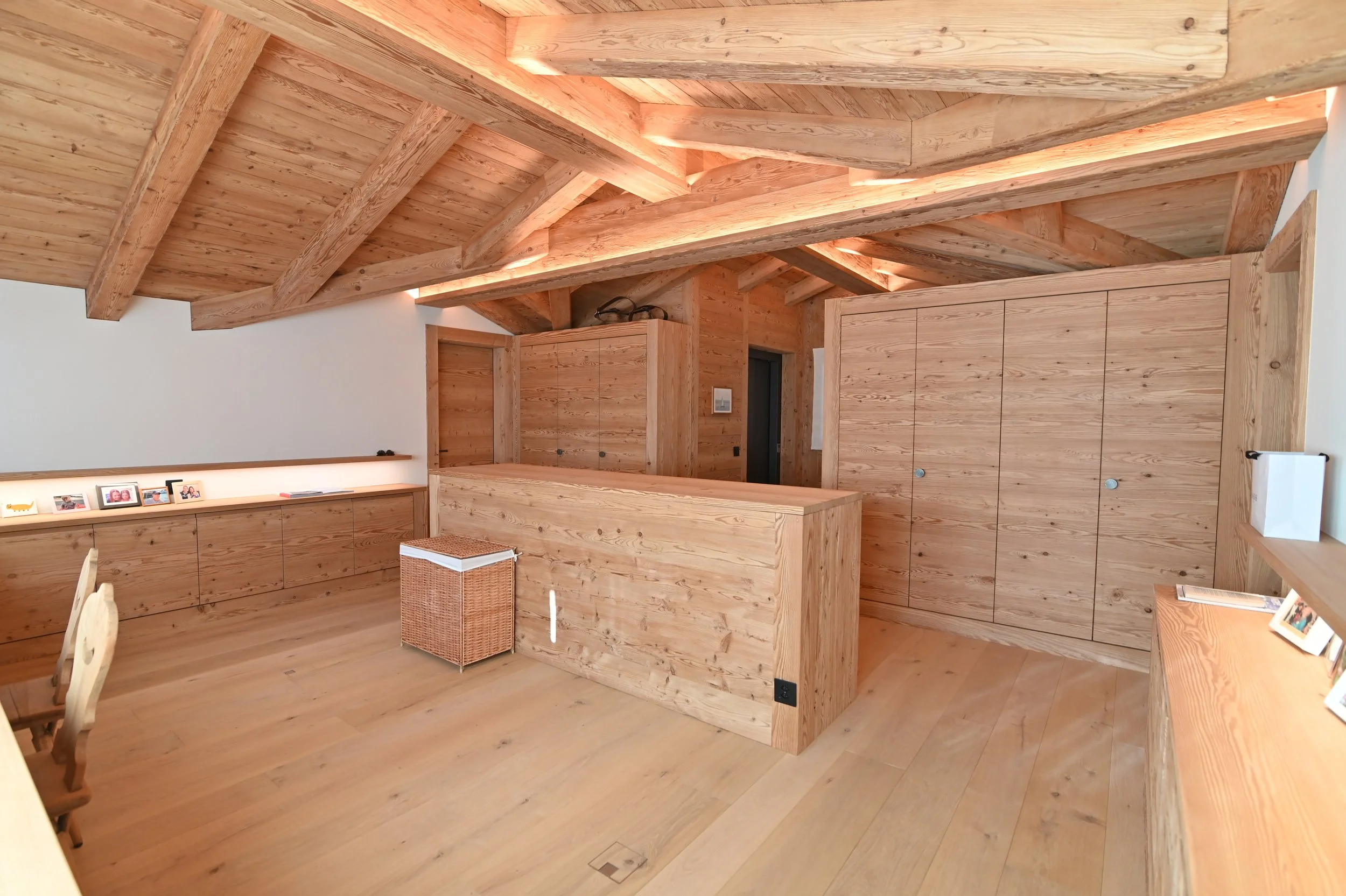 Innenraum mit Holzdecke, Holzwandverkleidung, Holzmöbeln und Assistenten-Tisch, natürliche Beleuchtung.