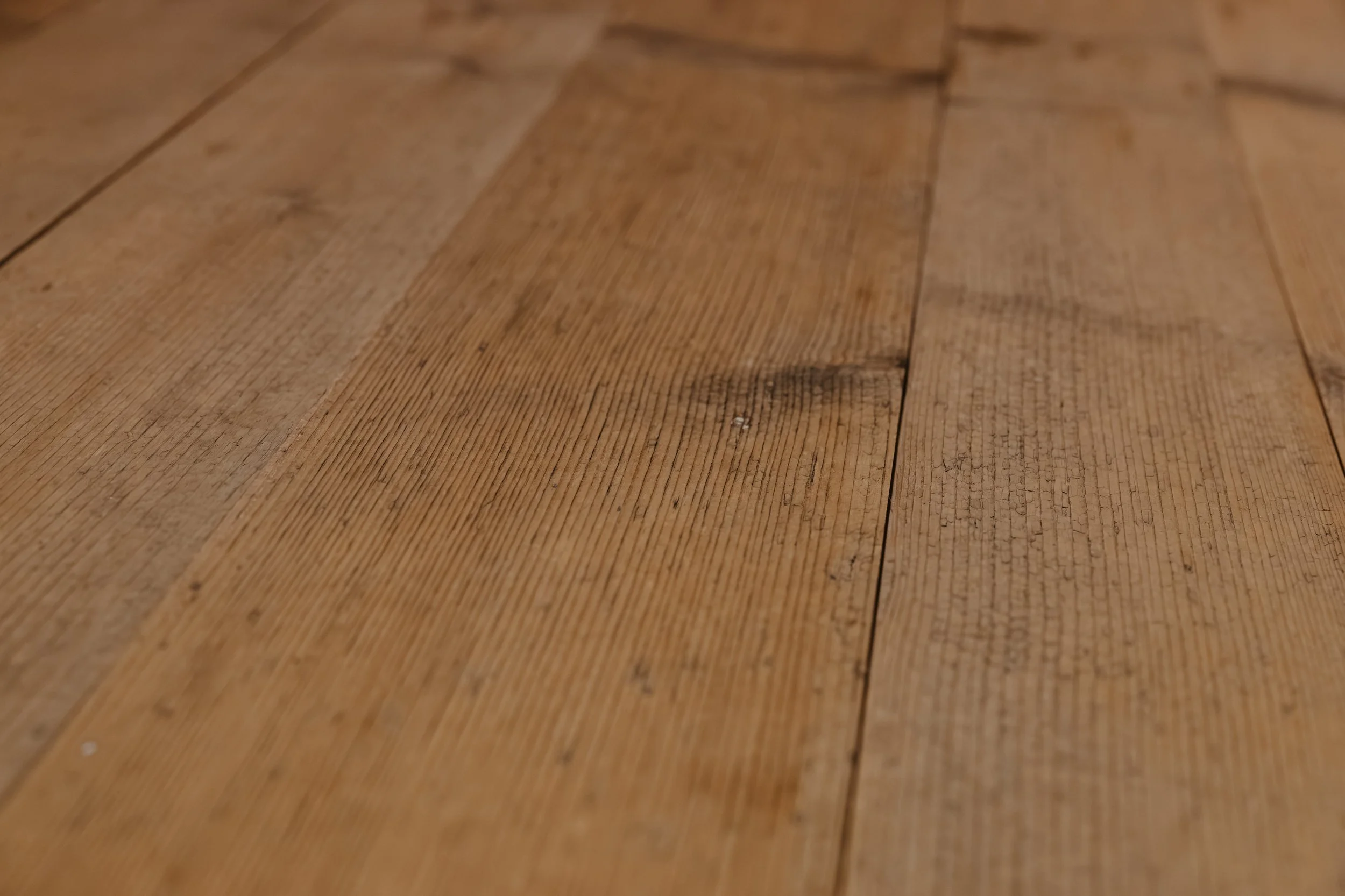Nahaufnahme von Holzplanken mit sichtbaren Maserungen und Knoten.