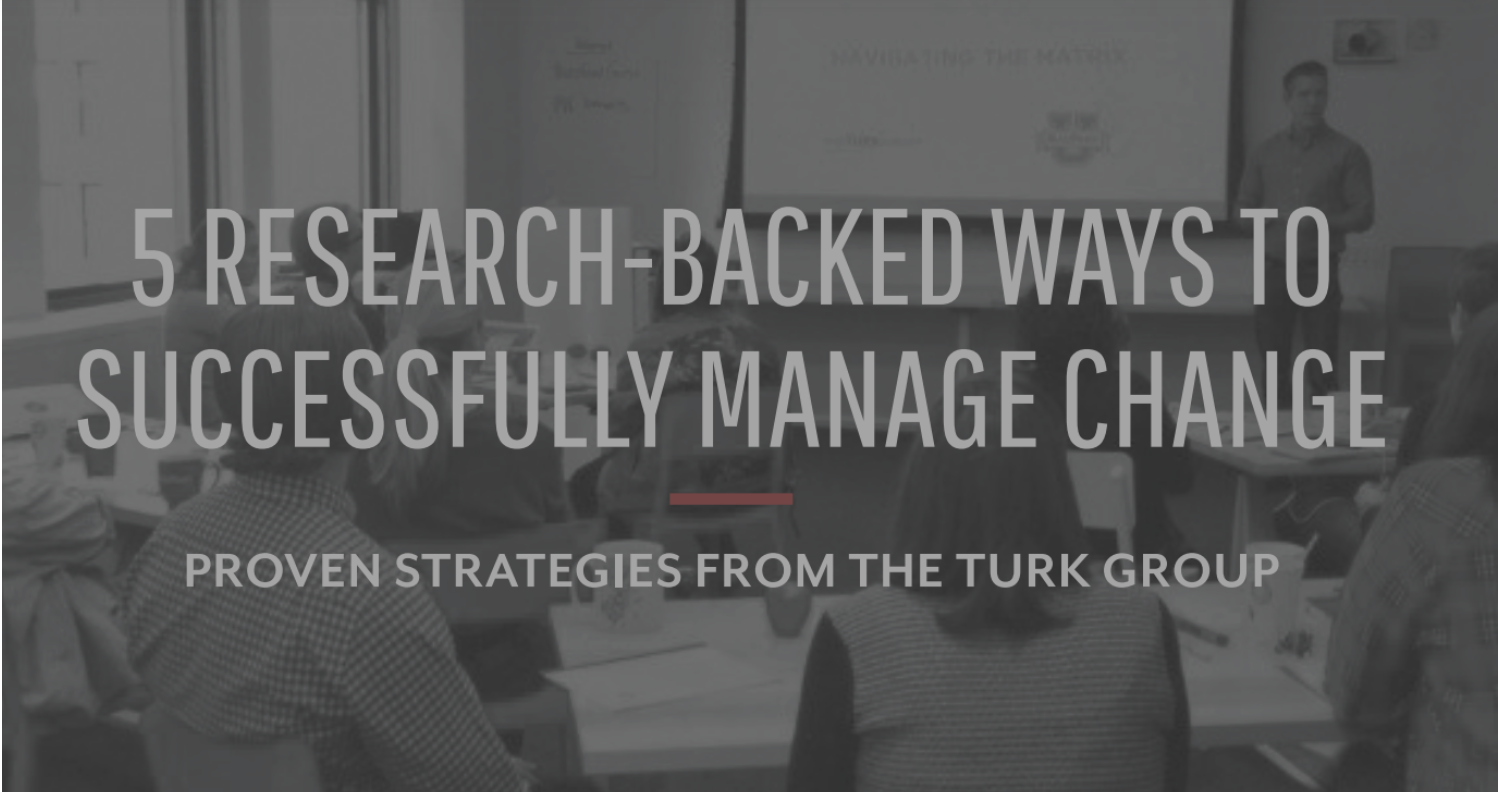 Presentation slide titled '5 Research-Backed Ways to Successfully Manage Change' with a subtitle 'Proven Strategies from the Turk Group' and a background showing a man giving a presentation to an audience in a conference room.