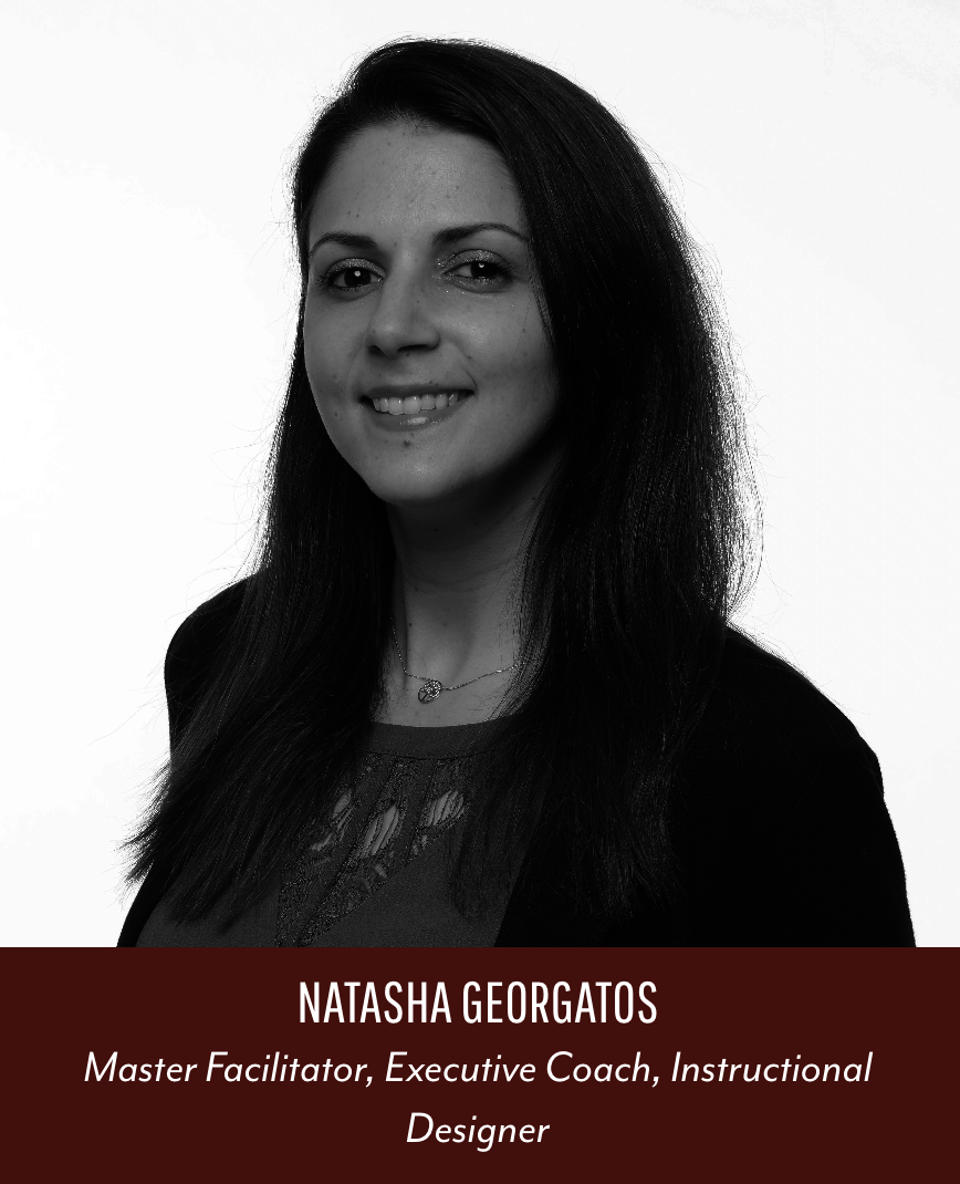 Black and white portrait of Natasha Georgatos smiling, wearing a blazer and a necklace, with a red banner at the bottom displaying her name and titles.