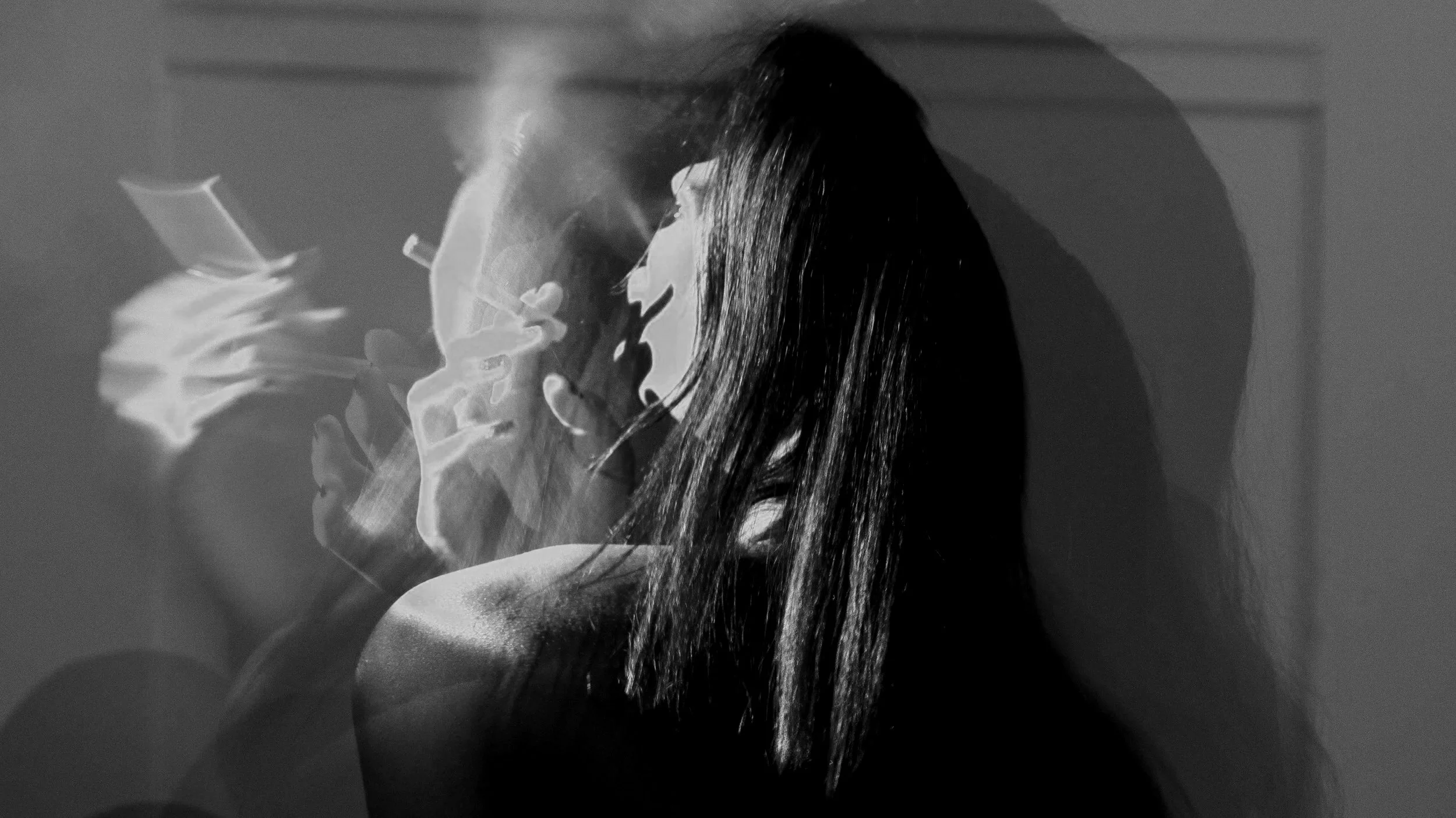 A woman with long hair smoking a cigarette in a dimly lit room, with multiple overlays of her profile and hand holding the cigarette creating a layered, abstract visual effect.