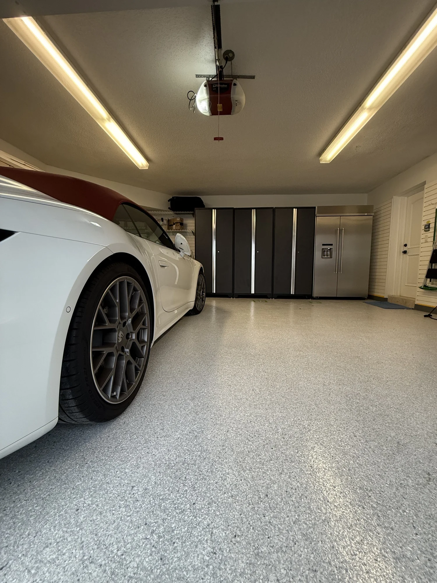 White sports car on a finished garage floor