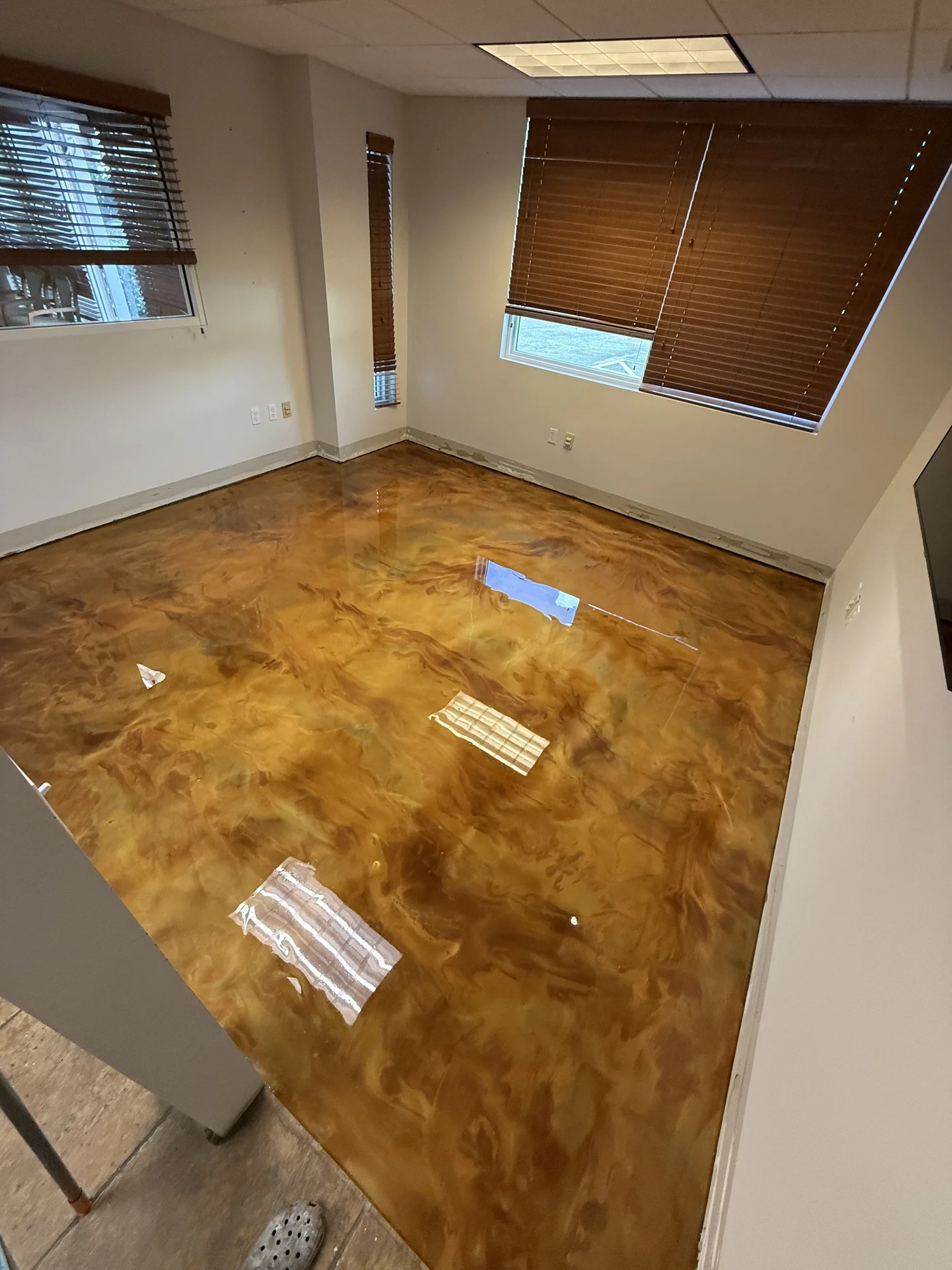 Glossy metallic epoxy floor in an empty room