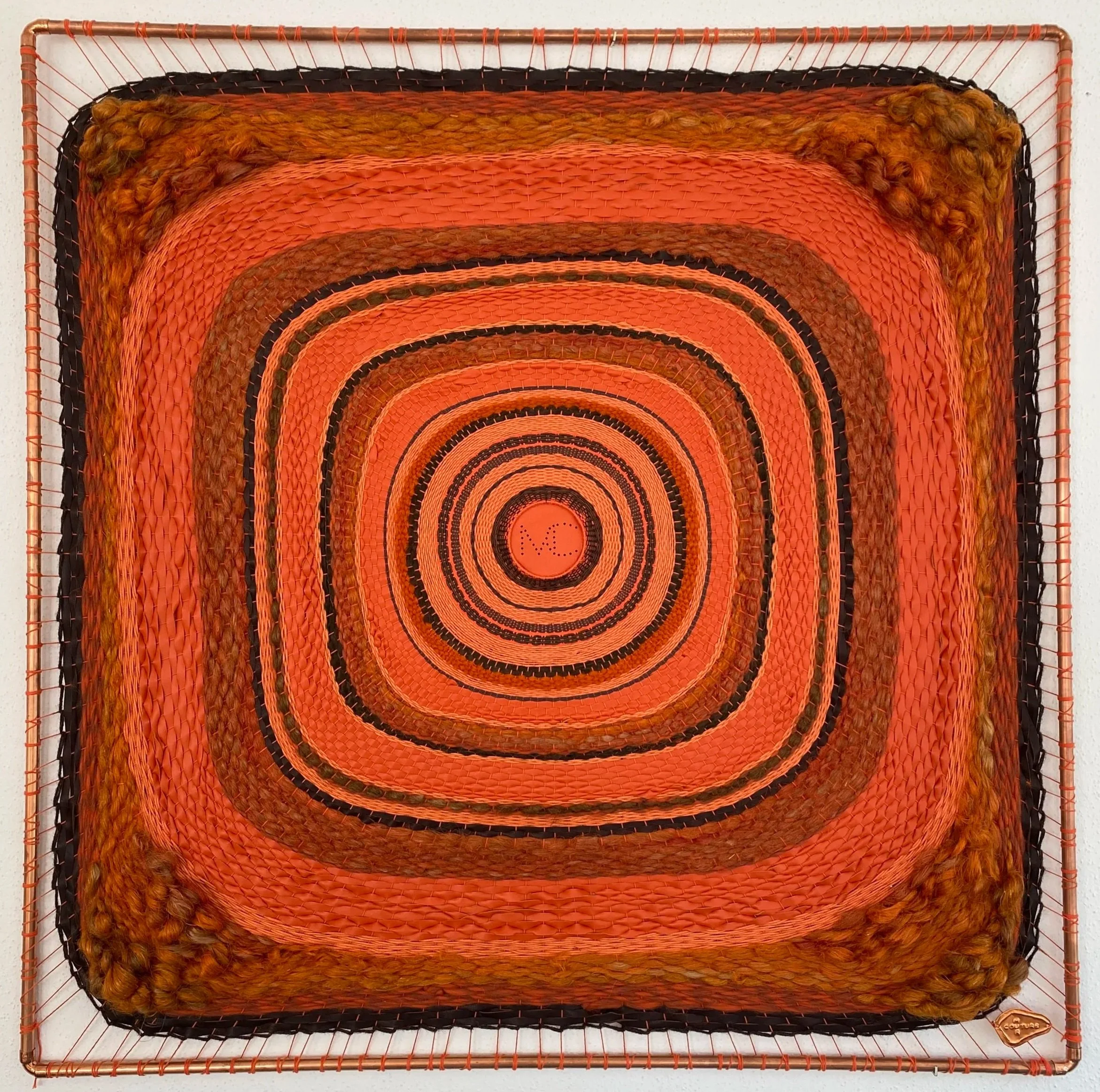 Mixed media square wall art with concentric square patterns in orange, black, and brown tones, featuring textured and woven elements.