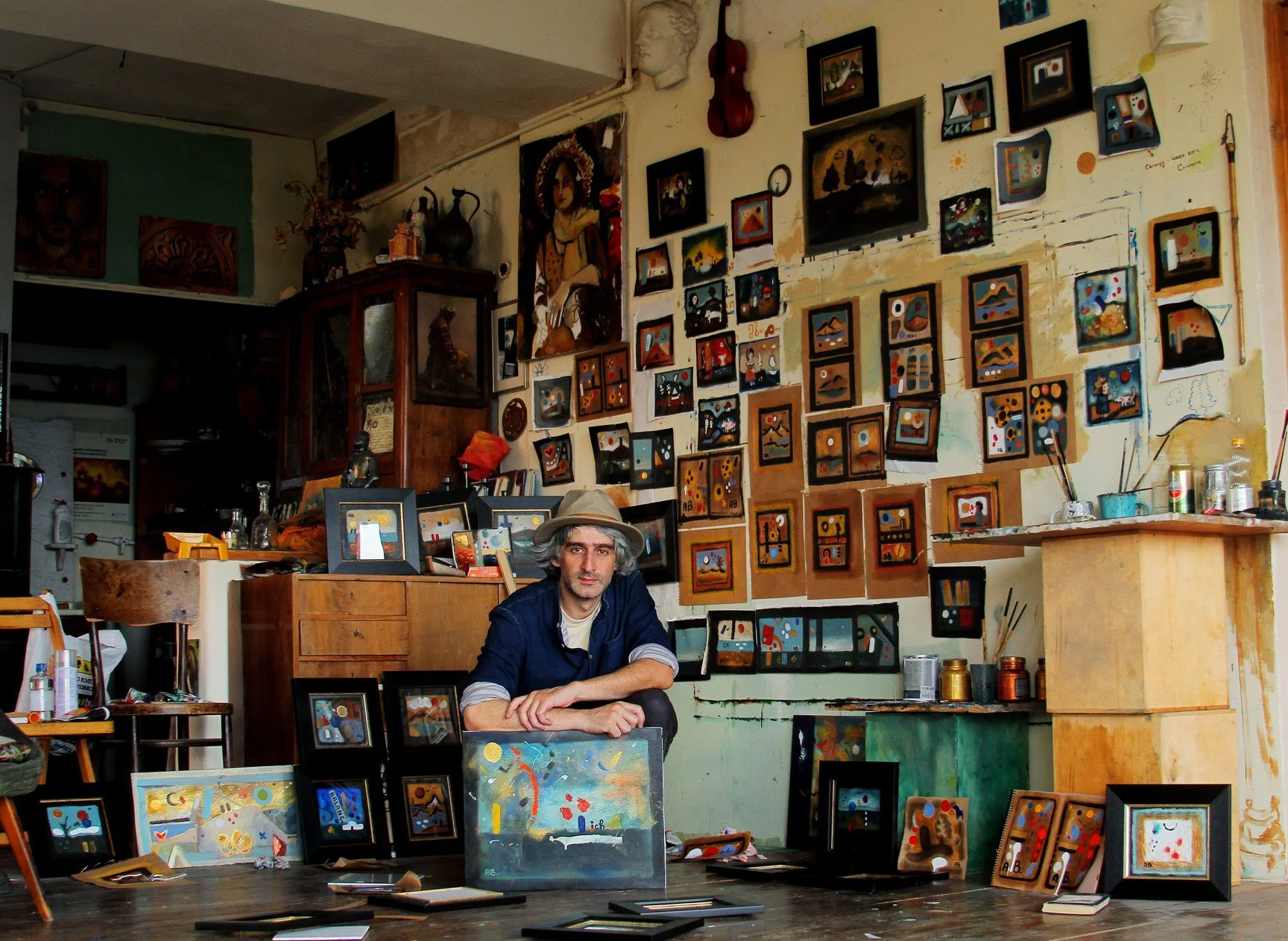 Painter Anton Balanchivadze in his studio, with paintings