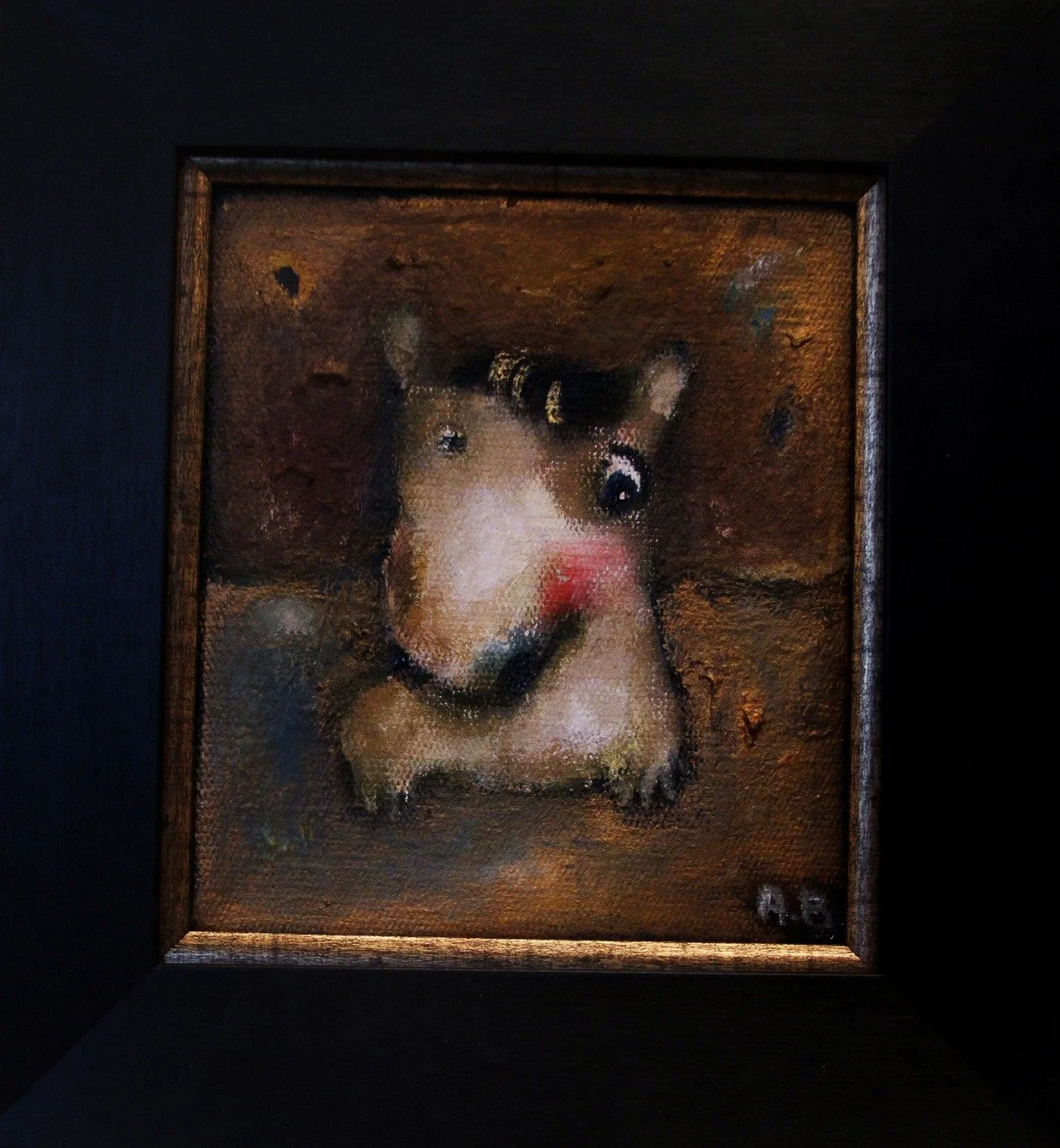 A small, painted portrait of a dog with a pink nose, black nose, and shiny black eyes, framed with a dark wooden border.