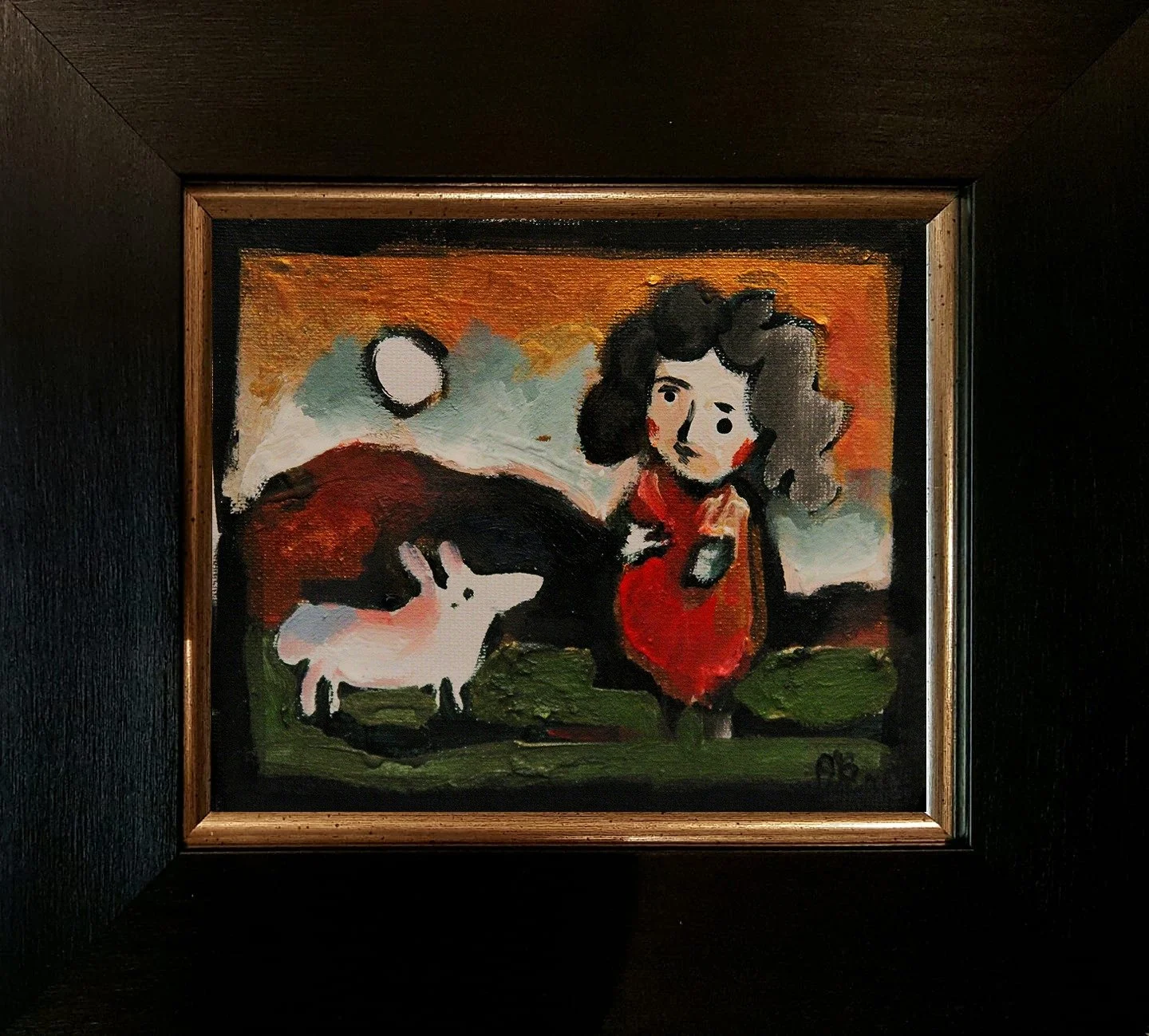 A colorful painting depicting a girl with curly hair in a red dress, standing next to a white pig, with a mountain and circular moon in the background, framed in wood.