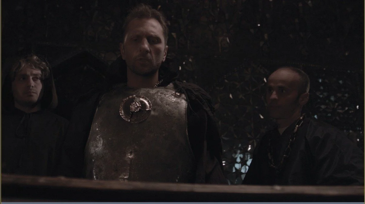 “The leading role is performed by actor Giorgi Megrelishvili, surrounded by the ‘servants’ — Levan Asanishvili and Sergo Sikharulidze — who await his decision.”