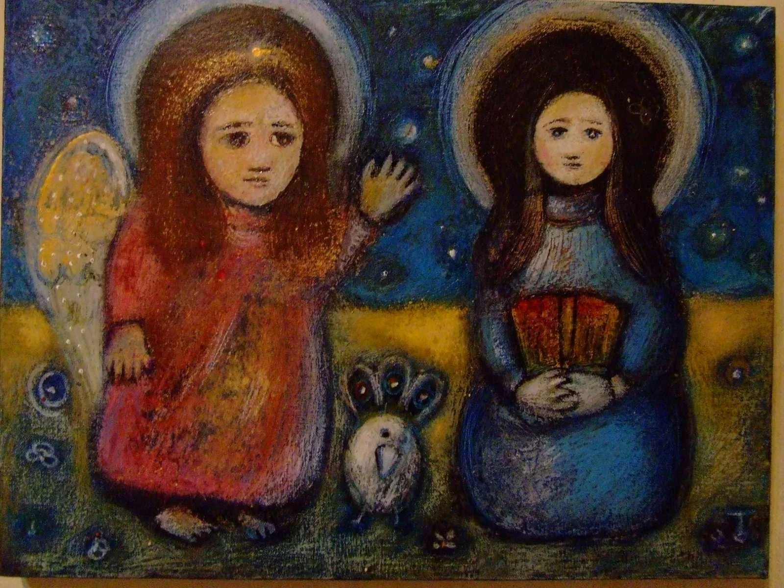 A religious painting depicting two angels, one with red hair on the left and one with dark hair on the right, surrounded by a dark sky filled with stars. The angel on the left is kneeling, wearing a red robe and holding a spear, with a halo around th