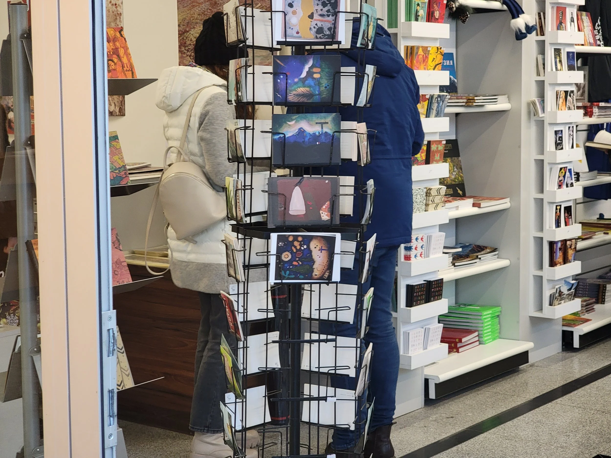 People shopping for books and artwork in a bookstore.