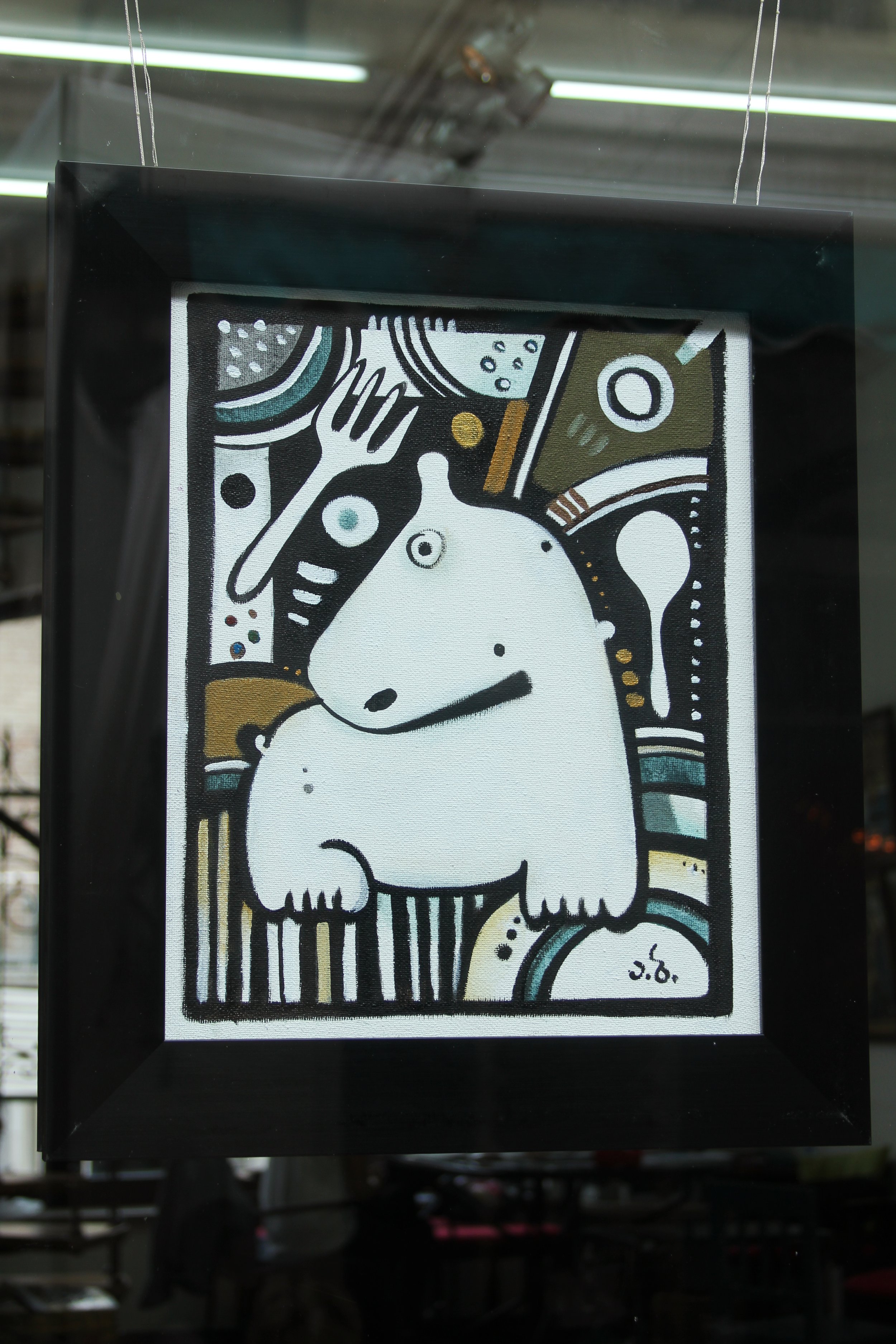 A framed abstract art print featuring a white animal, resembling a bear or dog, with a hand behind its head, surrounded by various geometric shapes and patterns in black, white, brown, and teal.