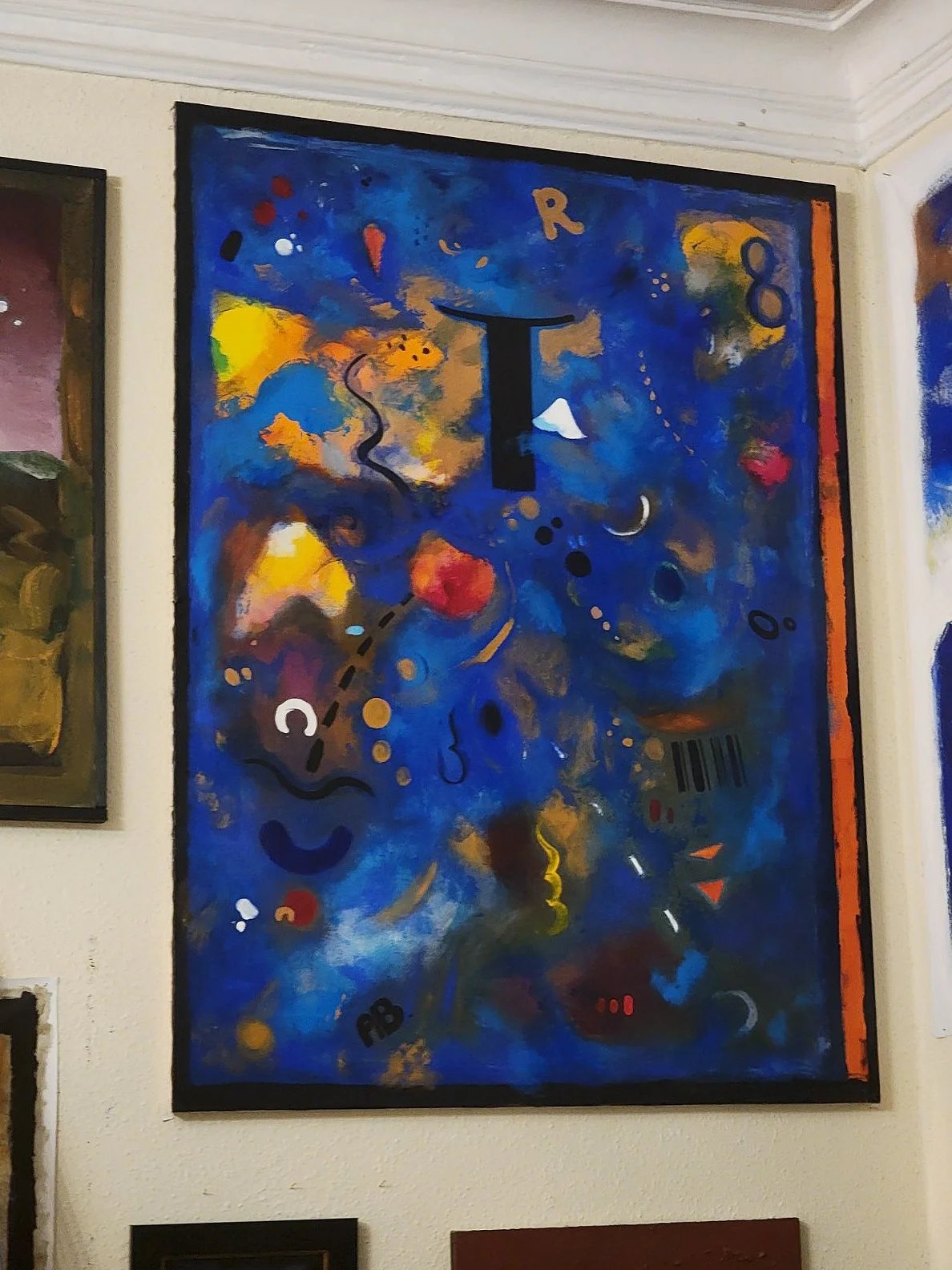 Abstract colorful painting with blue background, various shapes, symbols, and markings, including a large black letter "T" in the center.