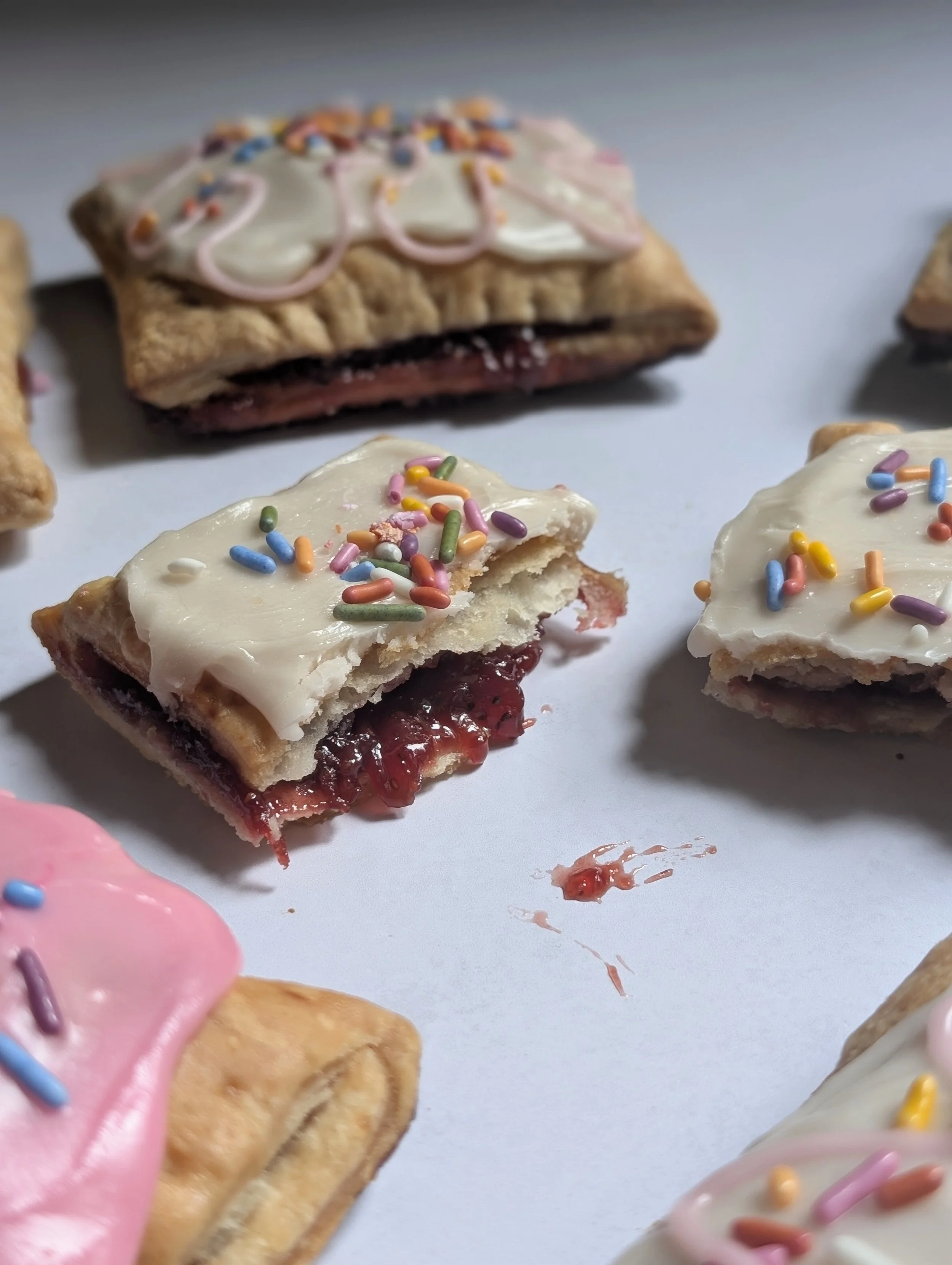pop-tarts with colorful sprinkles on a white surface.