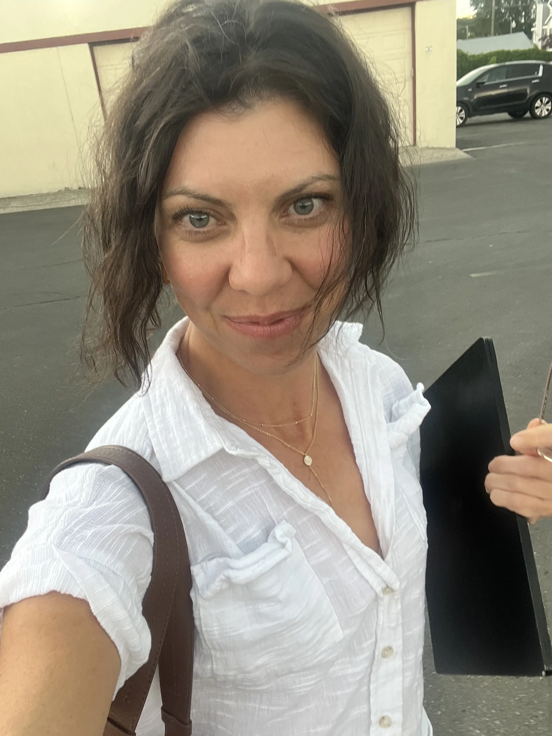 woman walking with laptop in purse in work parking lot