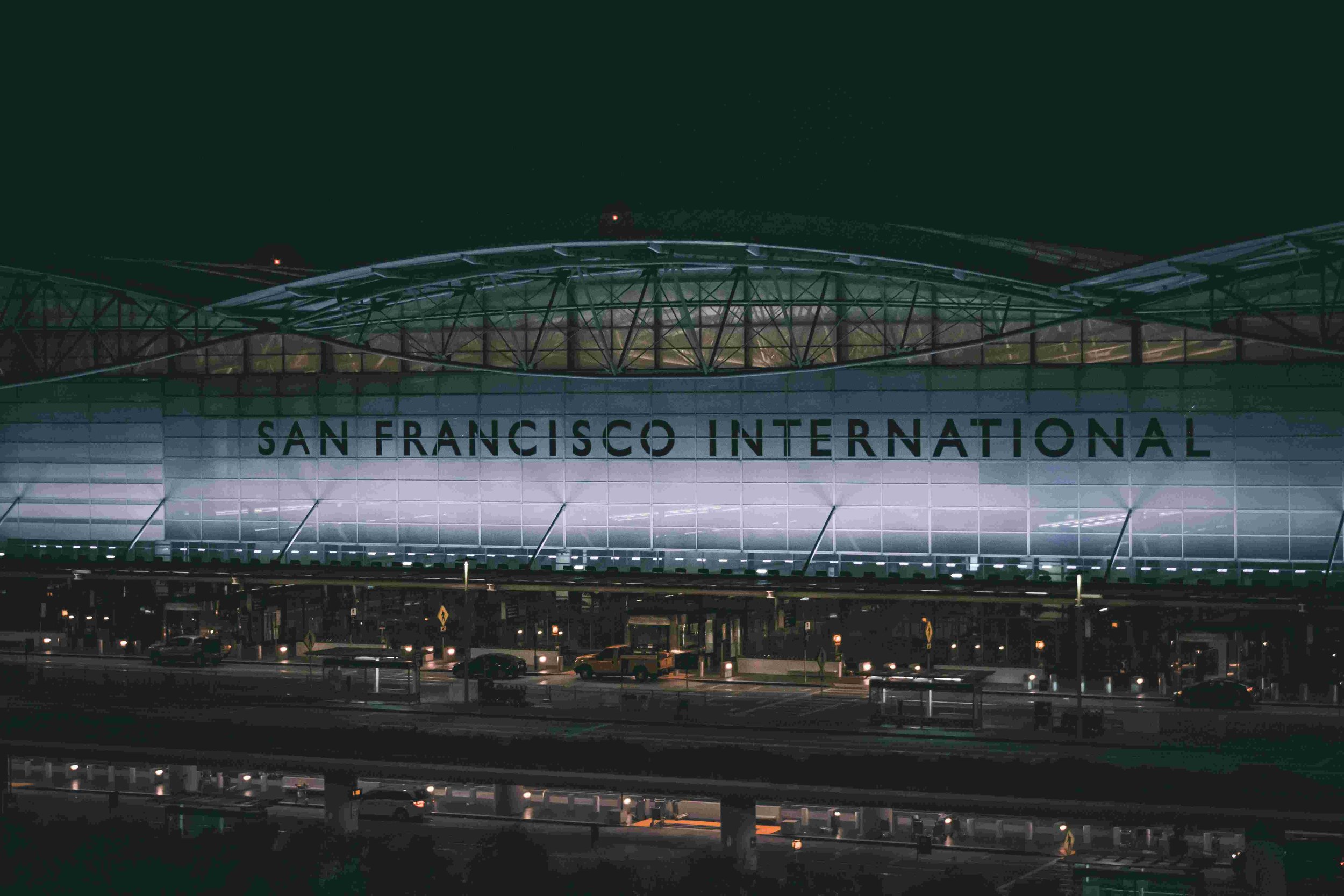 Night view of San Francisco International Airport terminal building with illuminated sign