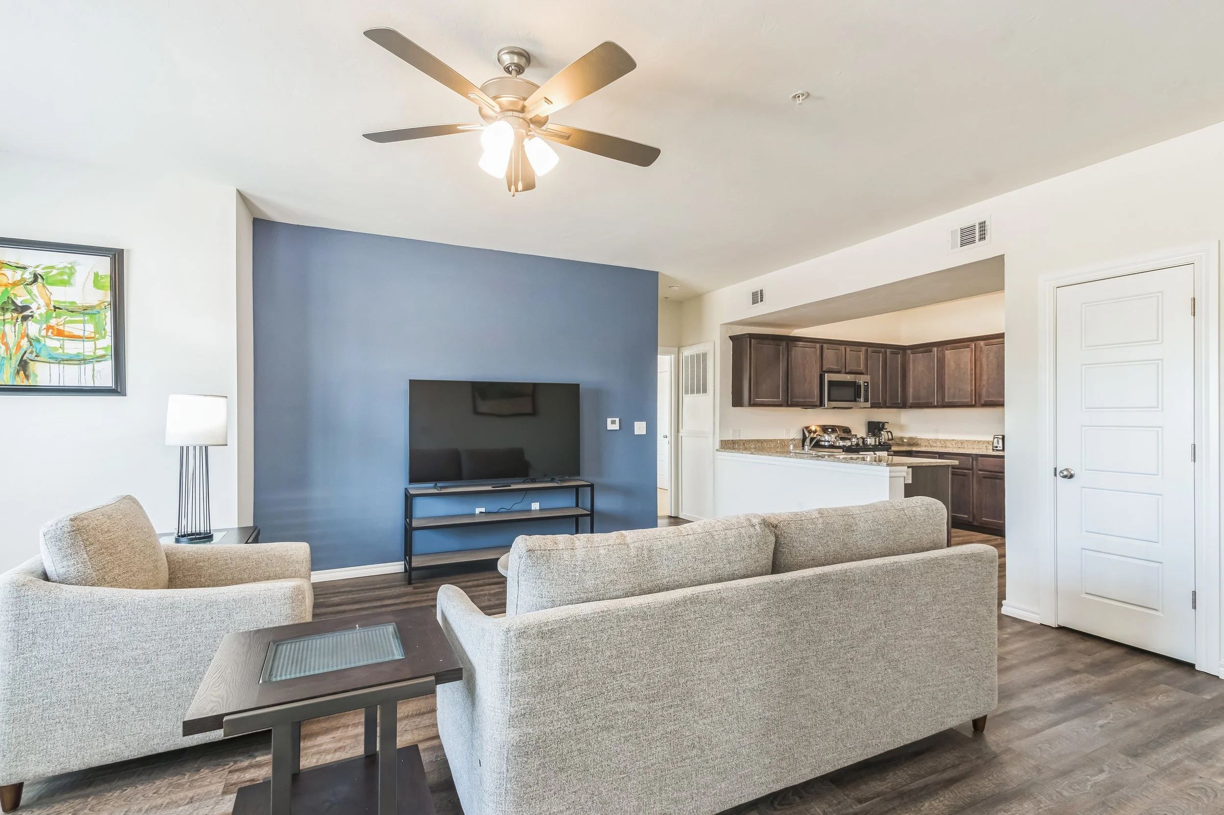 Furnished corporate housing living room with sofa, TV, and modern décor.