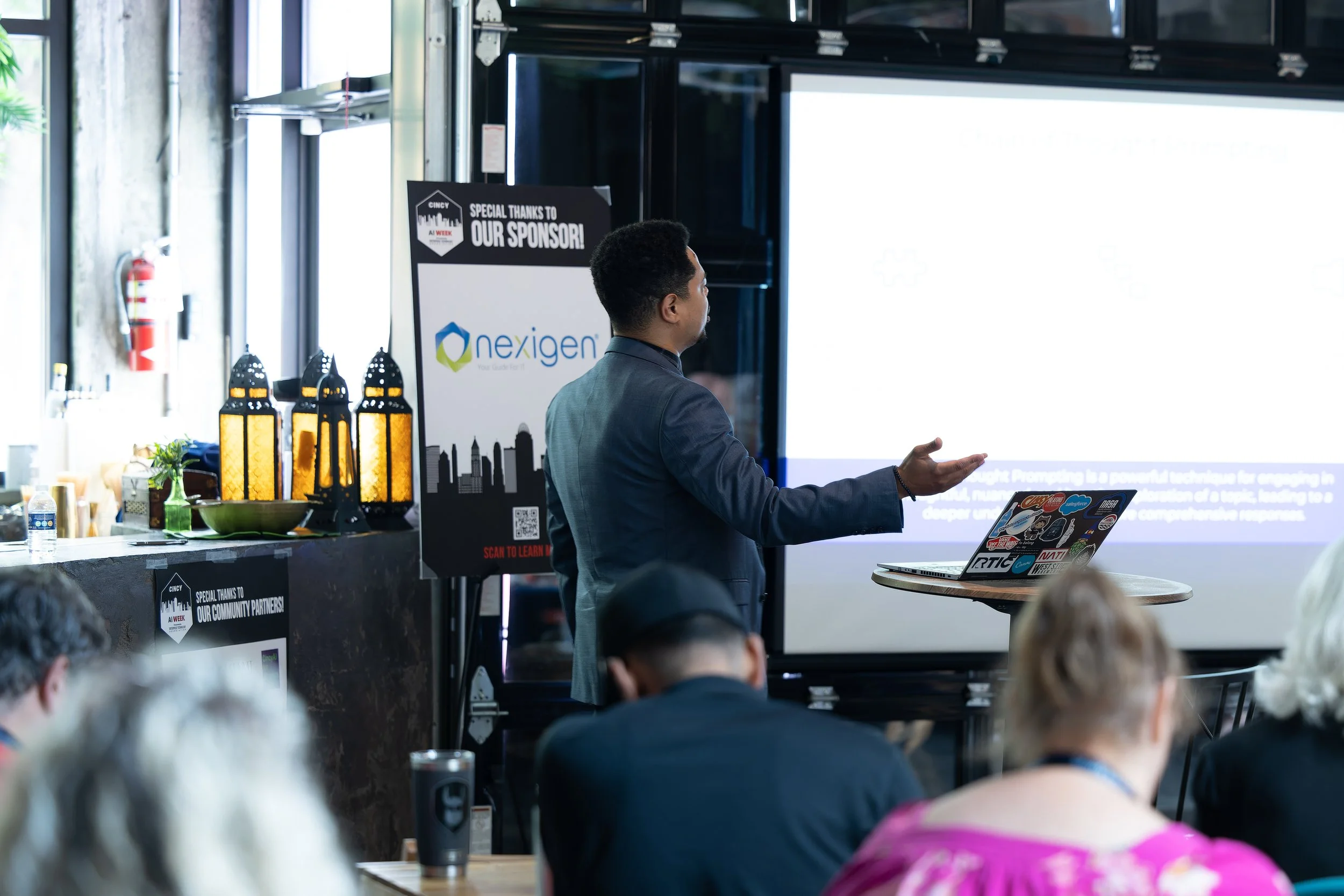 A black and white illustration of an open book with a feather quill pen resting on its pages.