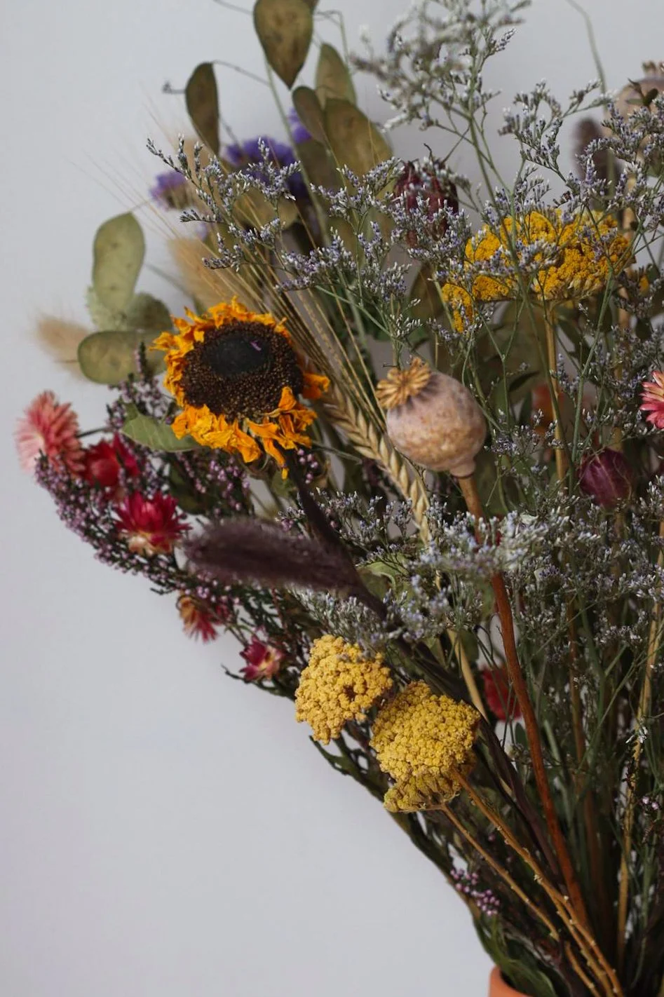 A bouquet of dried wildflowers and plants with various colors and textures.