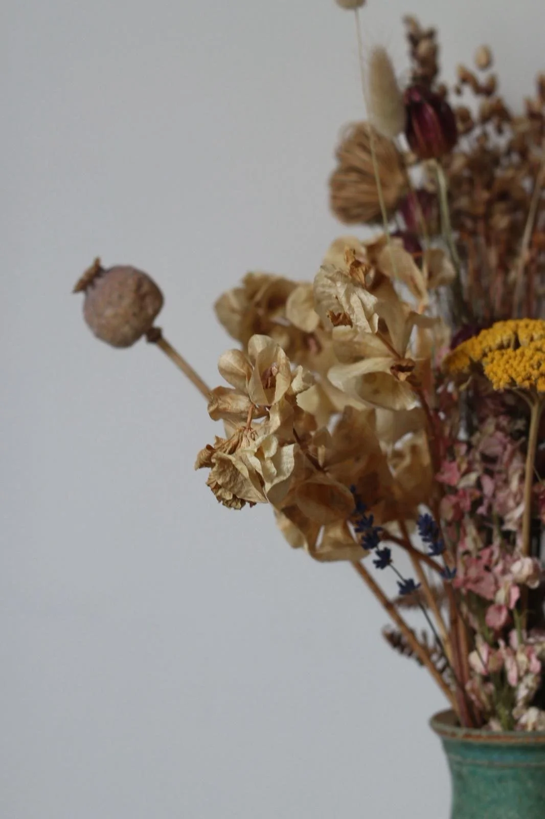 A bouquet of dried flowers in a vase with various colors and textures.