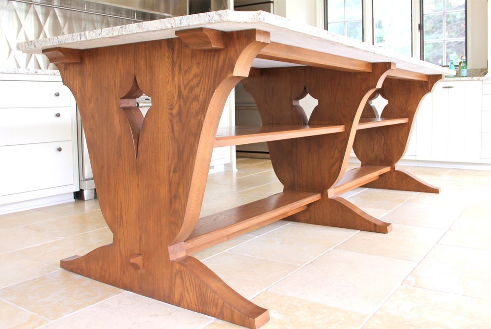 Wooden dining table with decorative curved legs in a bright kitchen.