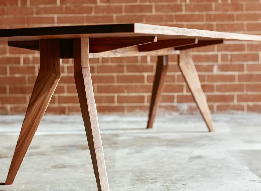 Low-angle view of a wooden table with a brick wall in the background.