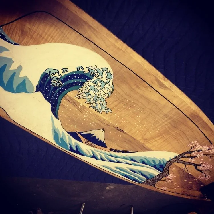 Wooden wall art depicting a stylized ocean wave and Mount Fuji with cherry blossoms.
