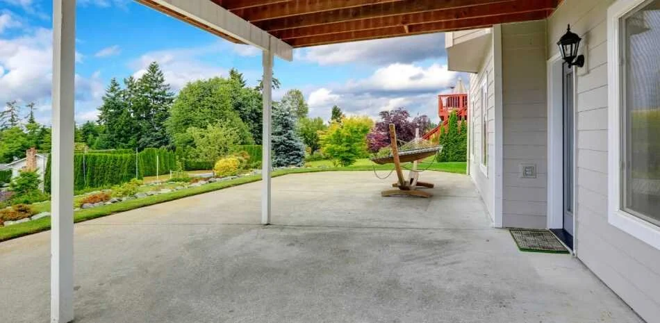 residential concrete patio with beautiful green landscaping and a hammock